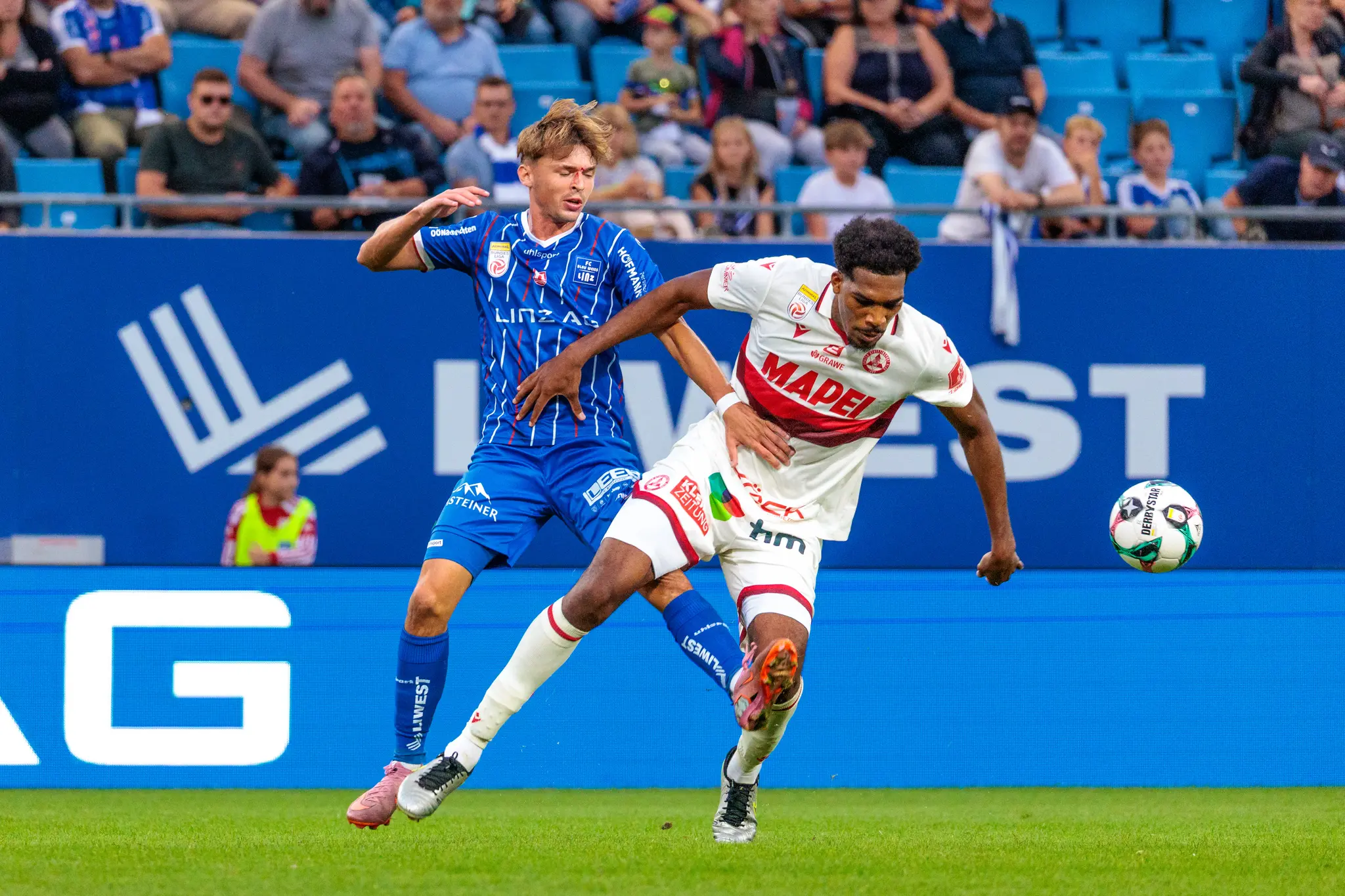 Der Blau-Weiß Linz Spieler Simon Seidl kämpft in einem intensiven Zweikampf gegen Sadik Fofana vom GAK