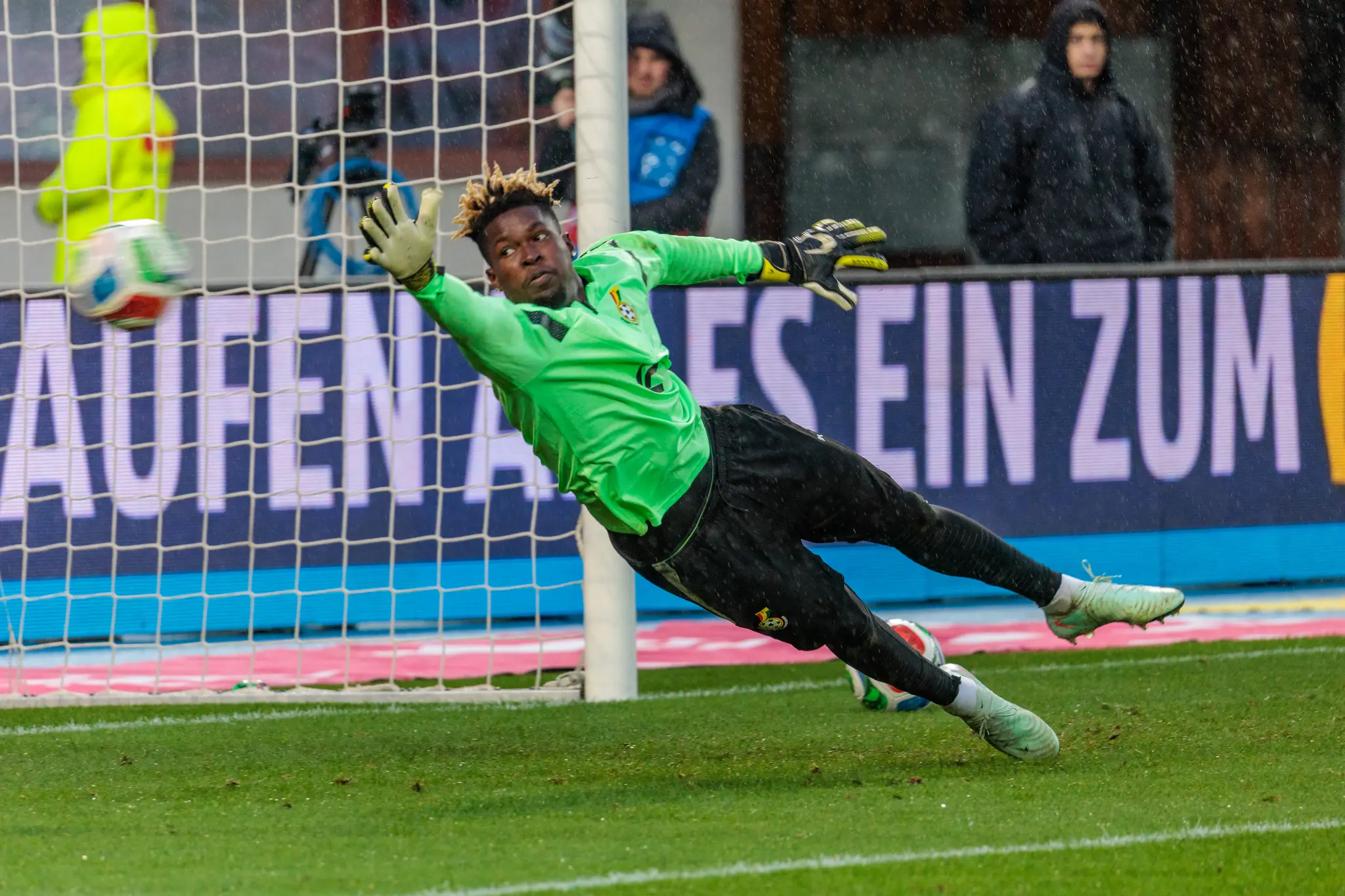 Der ghanaische Torwart Lawrence Ati Zigi in einem hellgrünen Trikot hechtet im WM-Testspiel Österreich gegen Ghana nach einem Fußball in Richtung Tornetz
