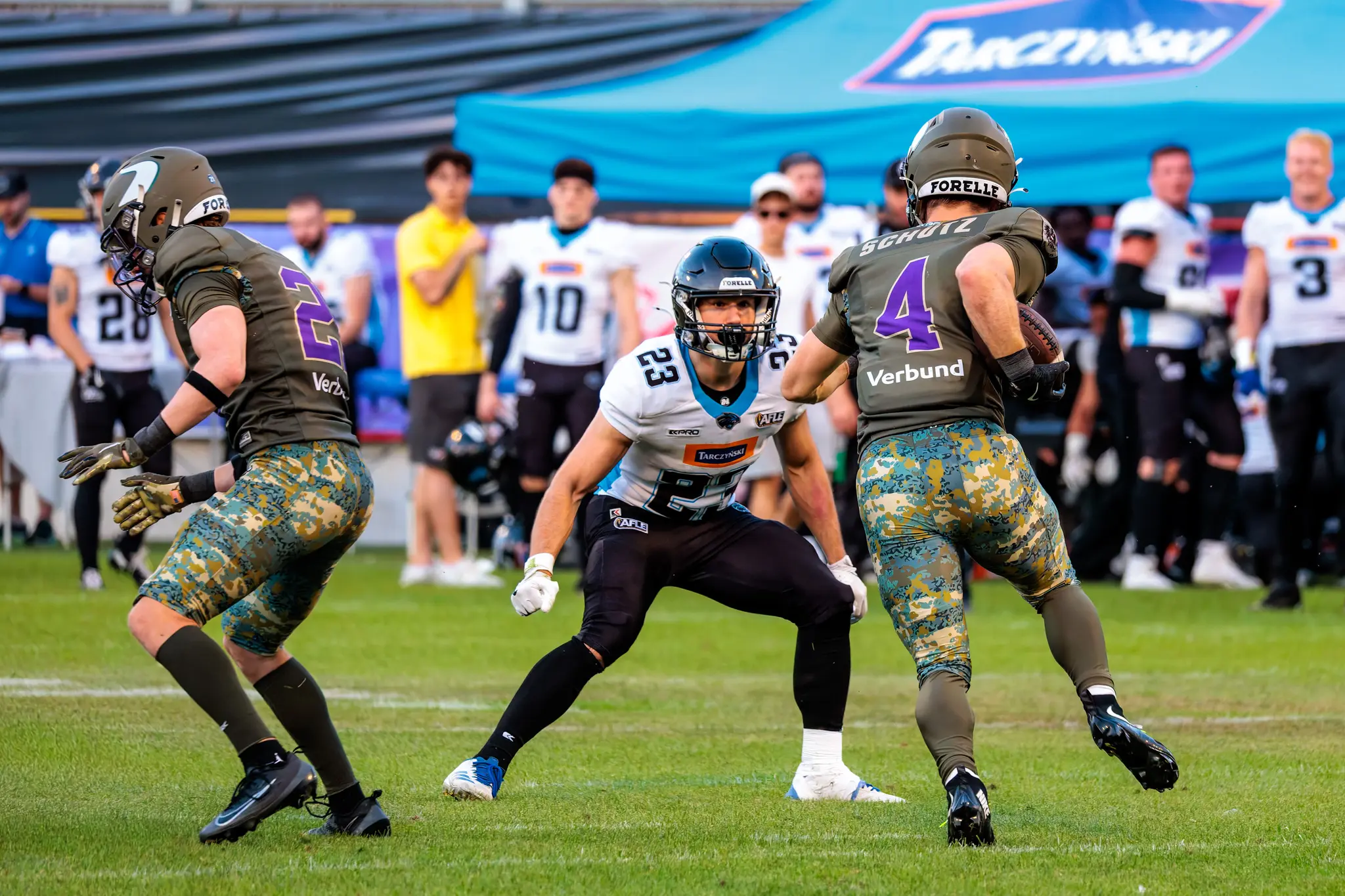 Vikings-Spieler Johannes Schütz (Nummer 4) läuft mit dem Ball, ein Blocker nimmt Panthers-Spieler Nummer 23.