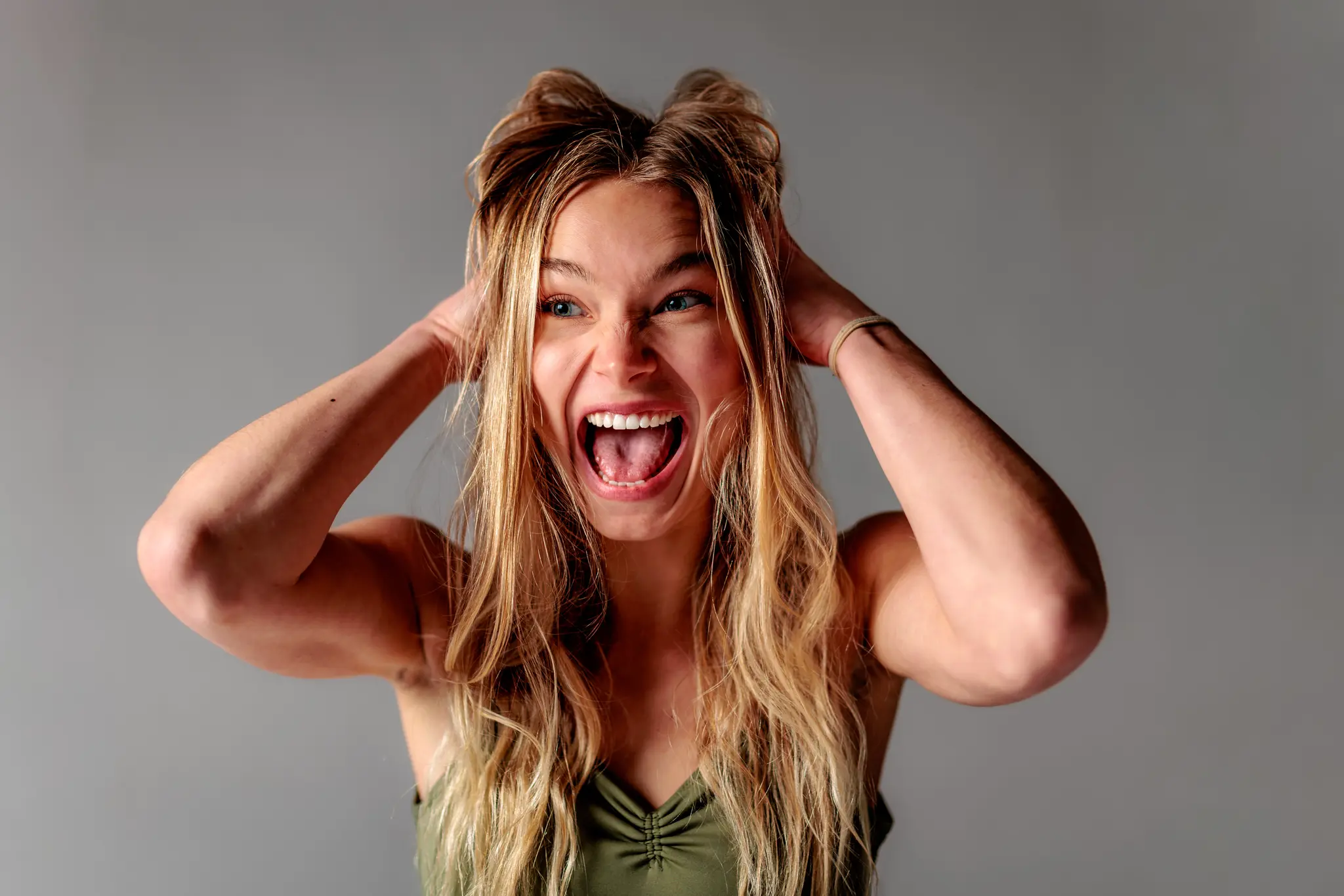 Expressives Studio-Portrait von Model Kathrin, die schreiend und mit den Händen am Kopf ihre emotionale Wandelbarkeit in einer dynamischen Session zeigt