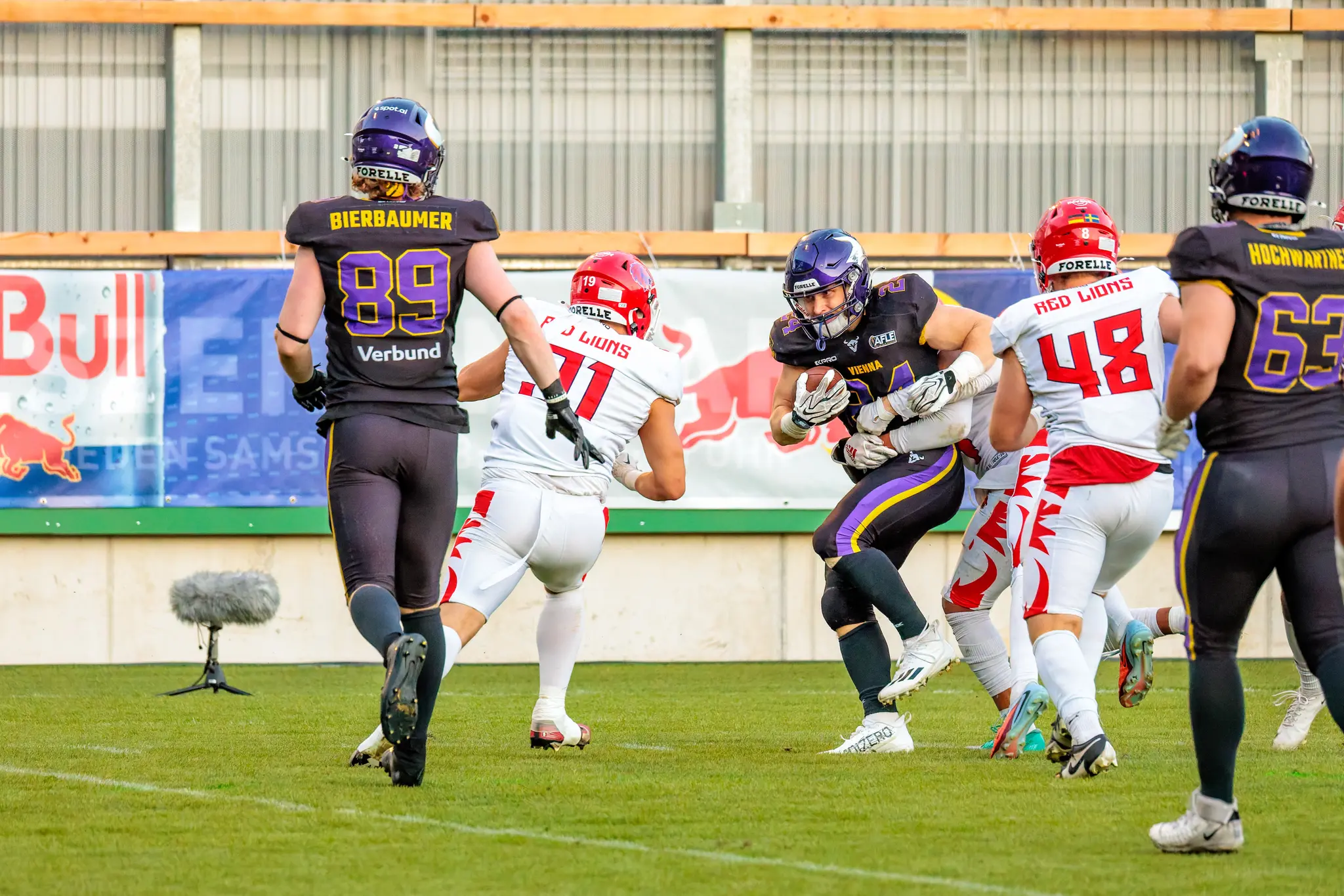 Karri Pajarinen (24) wird von zwei Red-Lions-Verteidigern umklammert und sichert den Ball eng am Körper – intensiver Zweikampf im Laufspiel der Vikings.