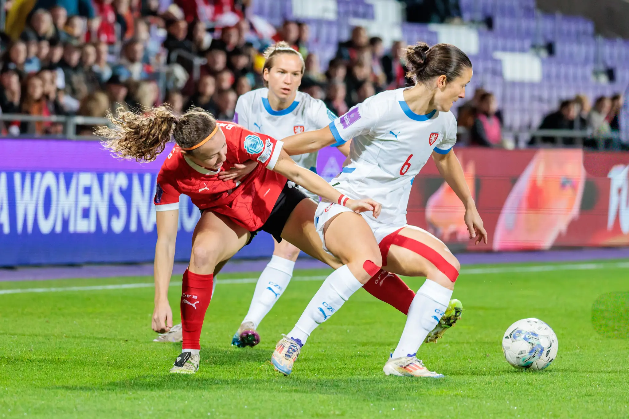 Österreichs Nationalspielerin Eileen Campbell in einem intensiven, körperbetonten Zweikampf um den Ball mit einer tschechischen Gegenspielerin