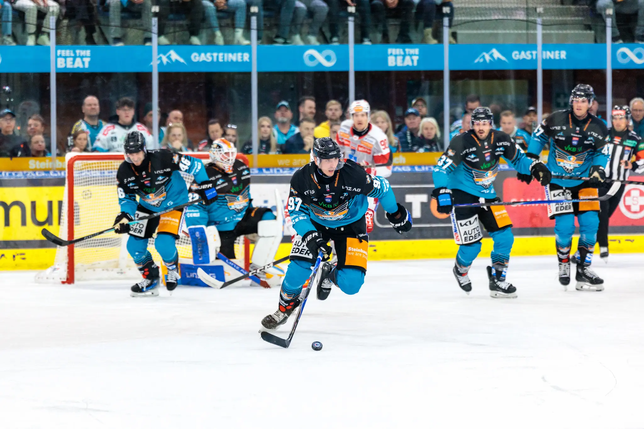 Der Stürmer der Steinbach Black Wings Linz, Luka Maver, mit der Nummer 97 führt den Puck im Angriff während eines Eishockeyspiels