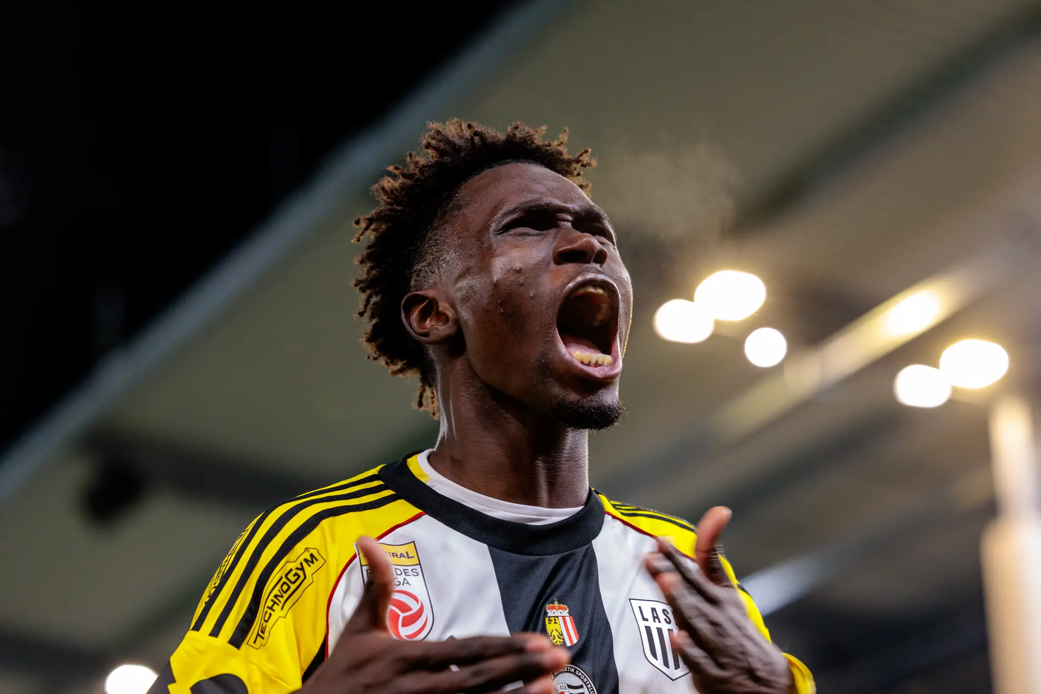Nahaufnahme des LASK-Spielers Modou Cisse, der emotional mit weit geöffnetem Mund jubelt und sein Atem in der kalten Luft sichtbar wird