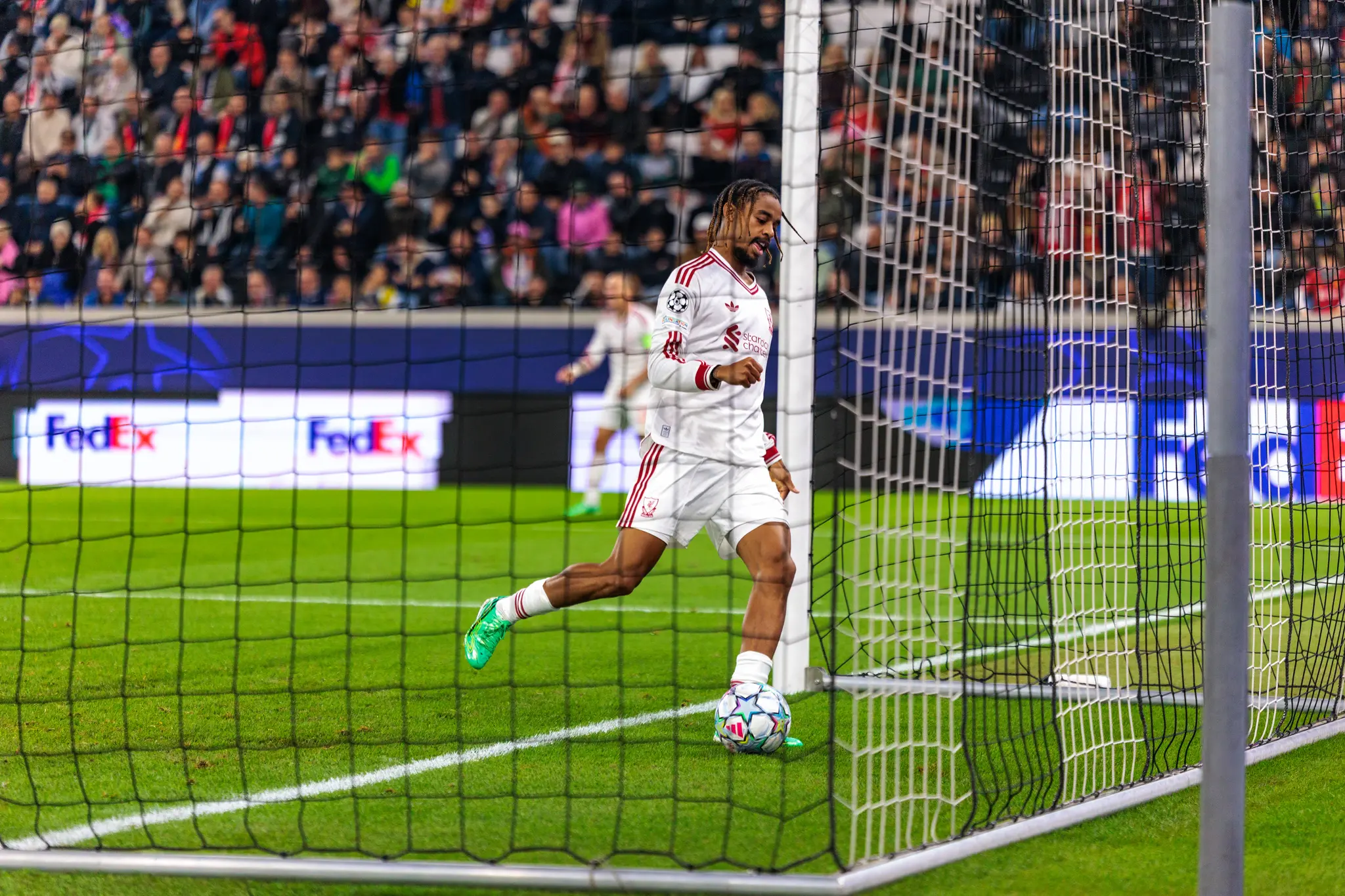 Durch das Tornetz fotografiert steht ein Liverpooler Spieler am langen Pfosten und blickt auf den Ball im Torraum – das 0:4 durch Jeremie Frimpong (30).