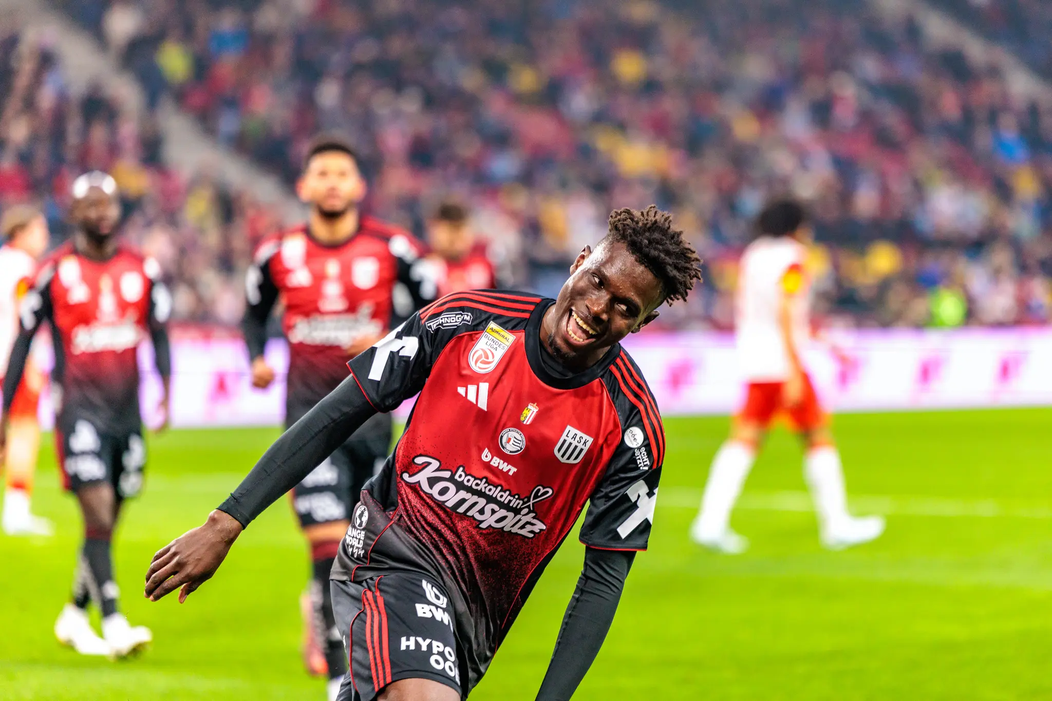 Ein freudig lachender LASK-Spieler in seinem rot-schwarzen Trikot jubelt während eines Bundesligaspiels gegen Red Bull Salzburg