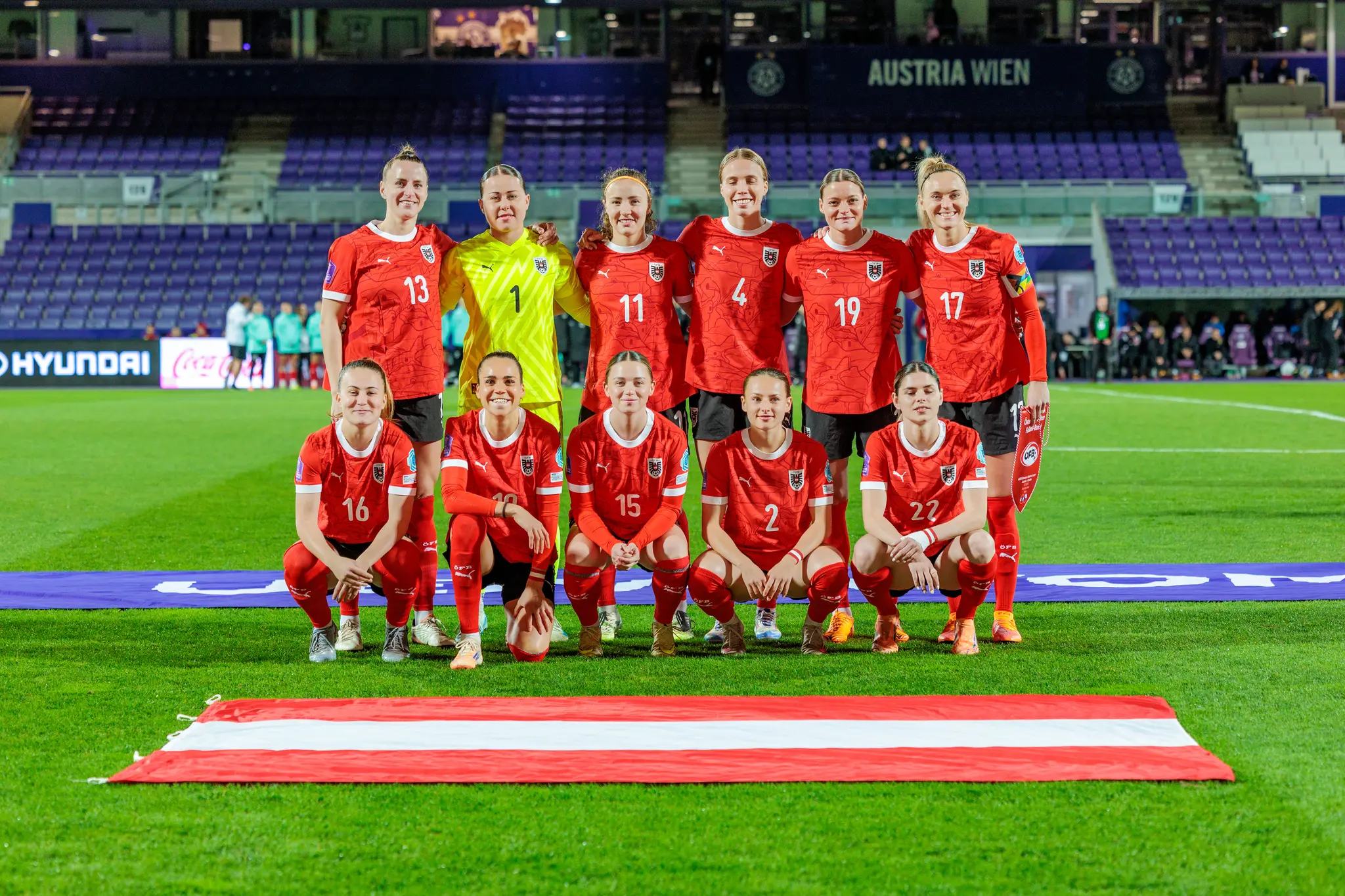 Das österreichische Frauen-Nationalteam stellt sich in der Generali-Arena für das Mannschaftsfoto auf, mit der österreichischen Flagge im Vordergrund