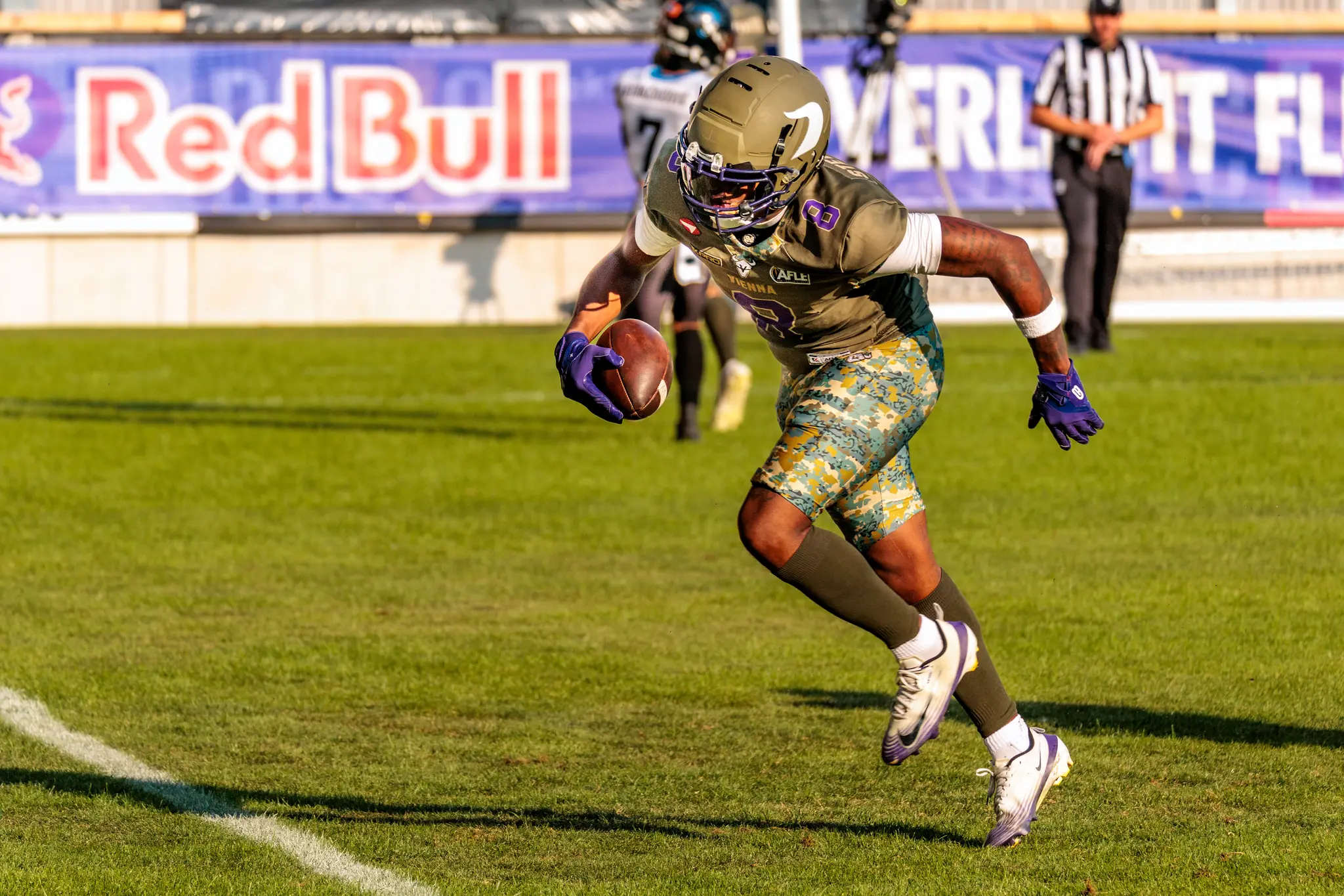 Vikings-Spieler Darrell Stewart Jr. (Nummer 8) trägt den Football an der Seitenlinie und beschleunigt durch die Abwehr.