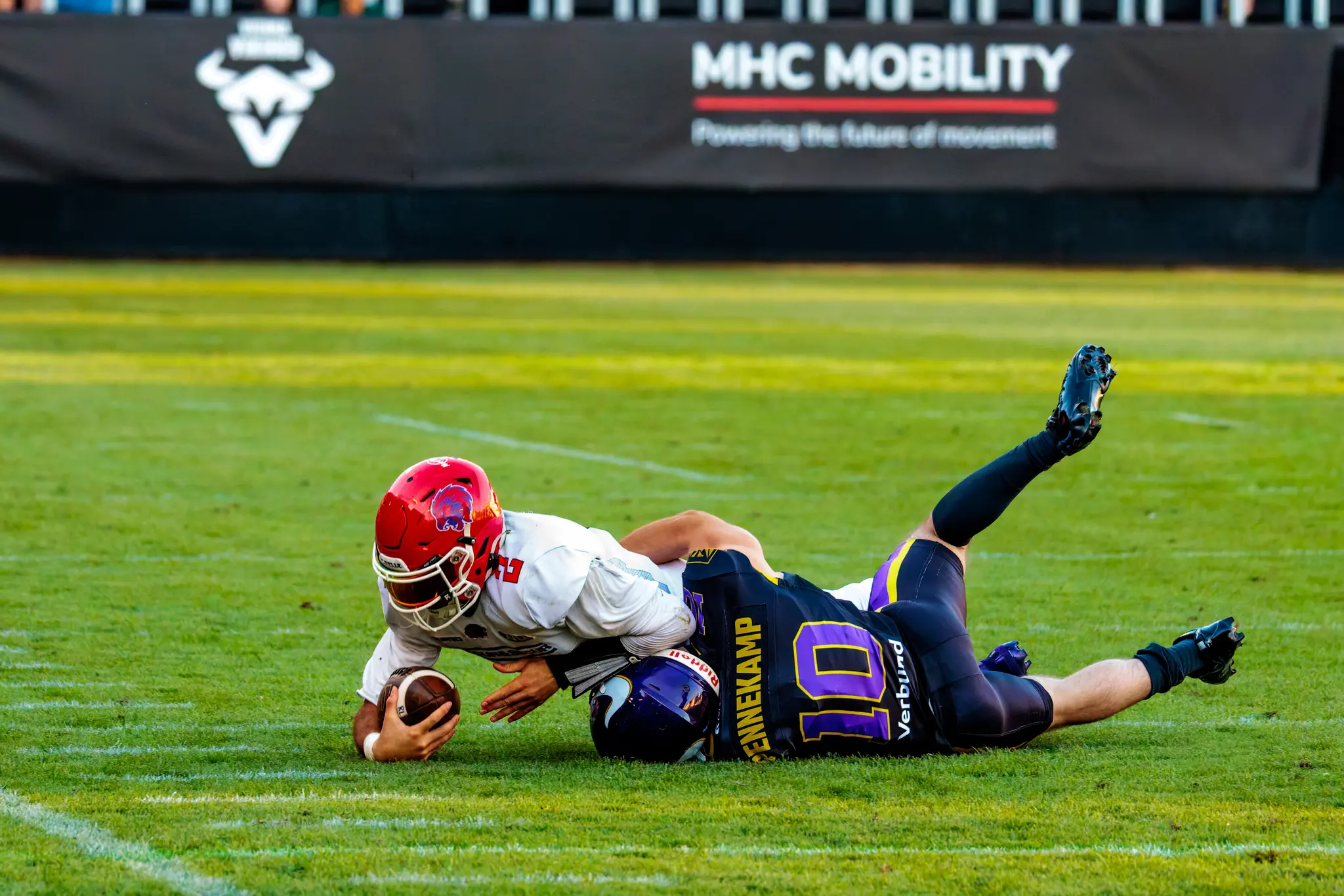 Der Tackle sitzt: Ein Vikings-Defender (10) zerrt den Red-Lions-Ballträger (2) zu Boden und fixiert ihn im Gras.