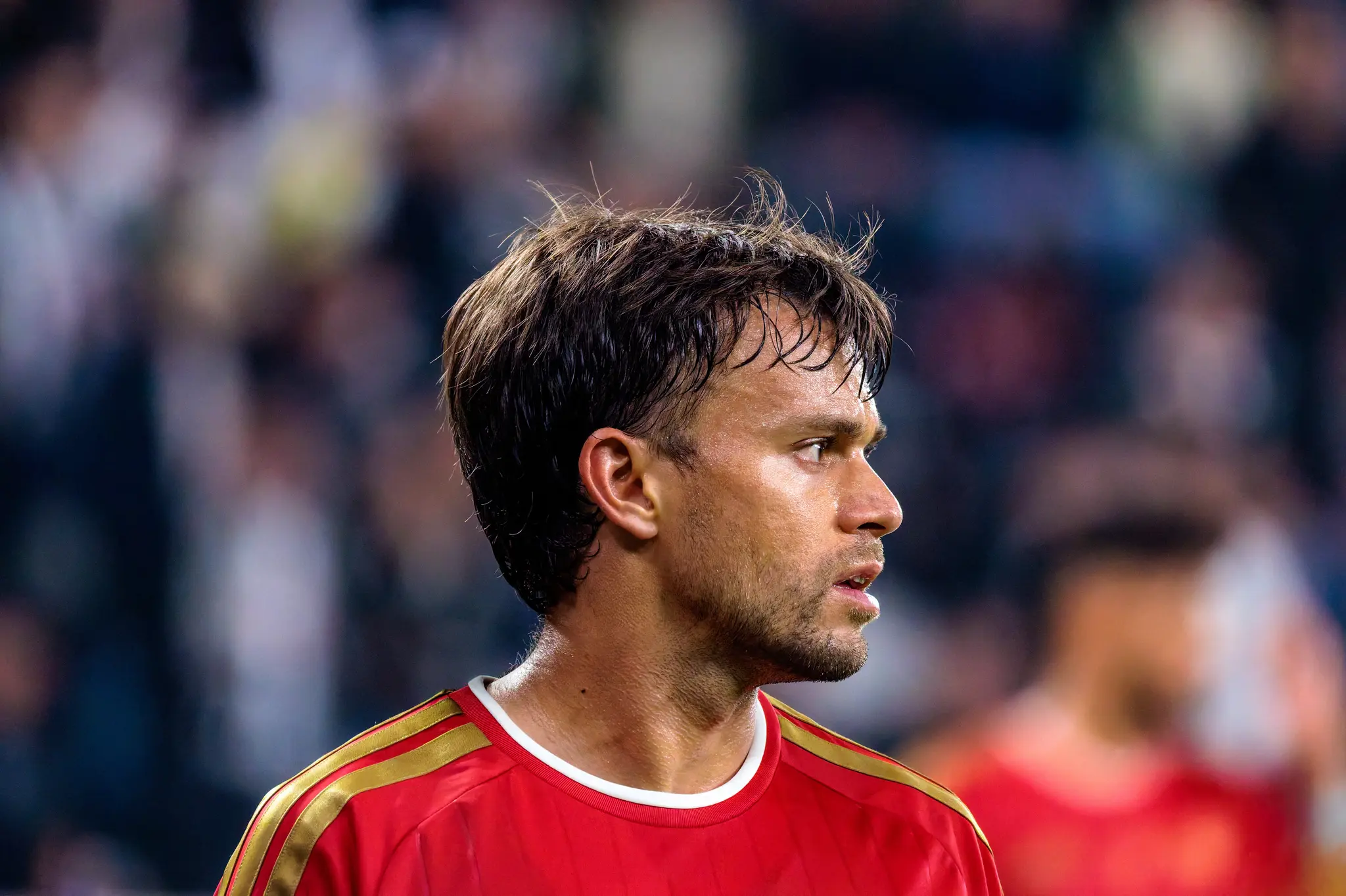 LASK-Kapitän Horvath (30) im Profilporträt, nasse Haare nach dem Regen, sein Blick ist auf das Spiel gerichtet.