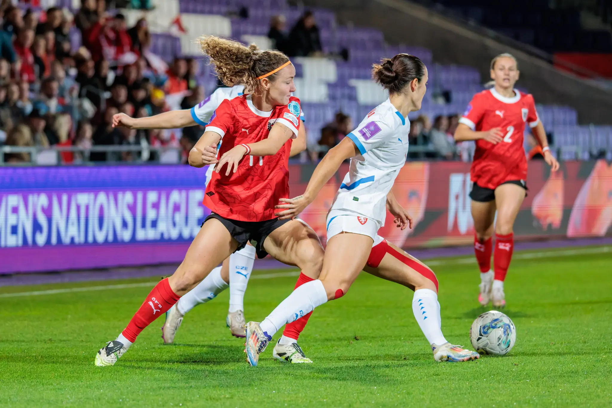Die österreichische Nationalspielerin Eileen Campbell dribbelt im roten Trikot in einem Zweikampf gegen eine tschechische Gegenspielerin