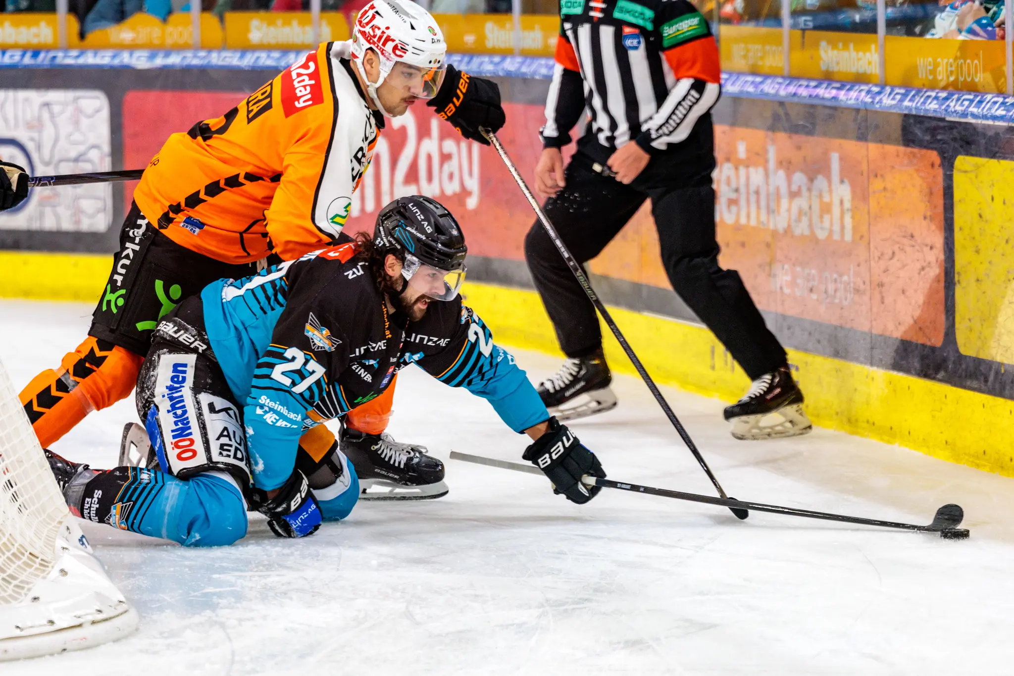 Der Eishockeyspieler Shawn St-Amant von den Steinbach Black Wings Linz kämpft auf den Knien im Duell mit Kevin Roy von den Graz99ers um den Puck