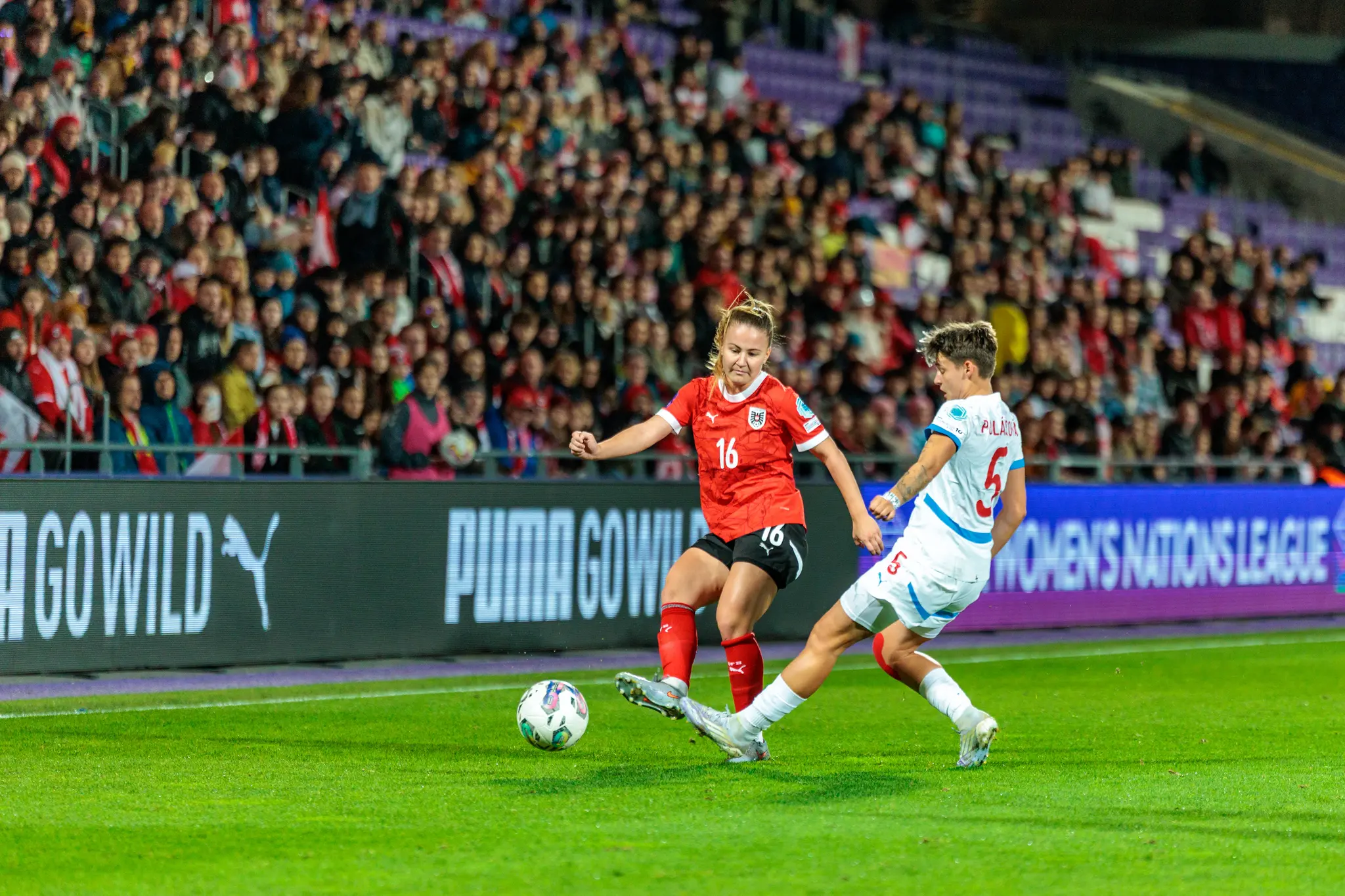 Die österreichische Nationalspielerin Lisa Kolb im roten Trikot mit der Nummer 16 dribbelt im Nations League-Spiel gegen eine tschechische Gegenspielerin