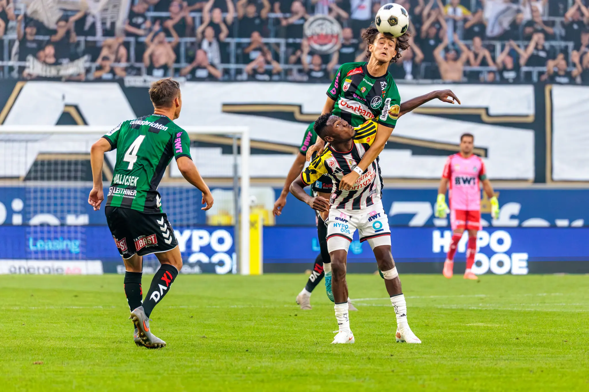 Luftzweikampf: Ein SV-Ried-Spieler und ein LASK-Spieler um den hohen Ball
