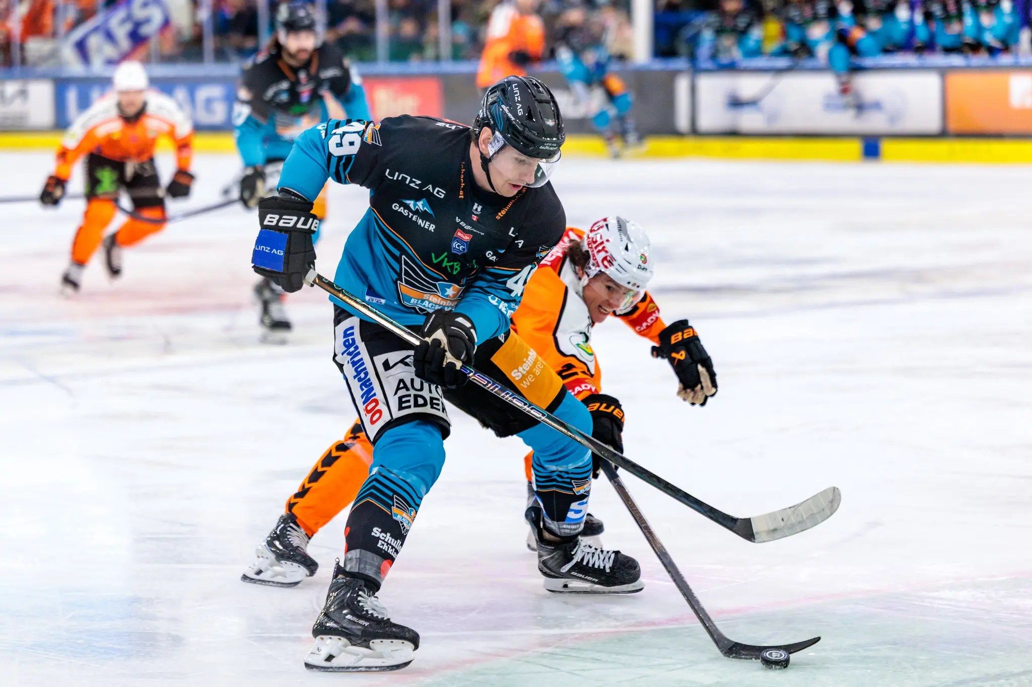 Der Eishockeyspieler Graham Knott von den Black Wings Linz kämpft in einem intensiven Duell gegen Nick Bailen von den Graz99ers um den Puck