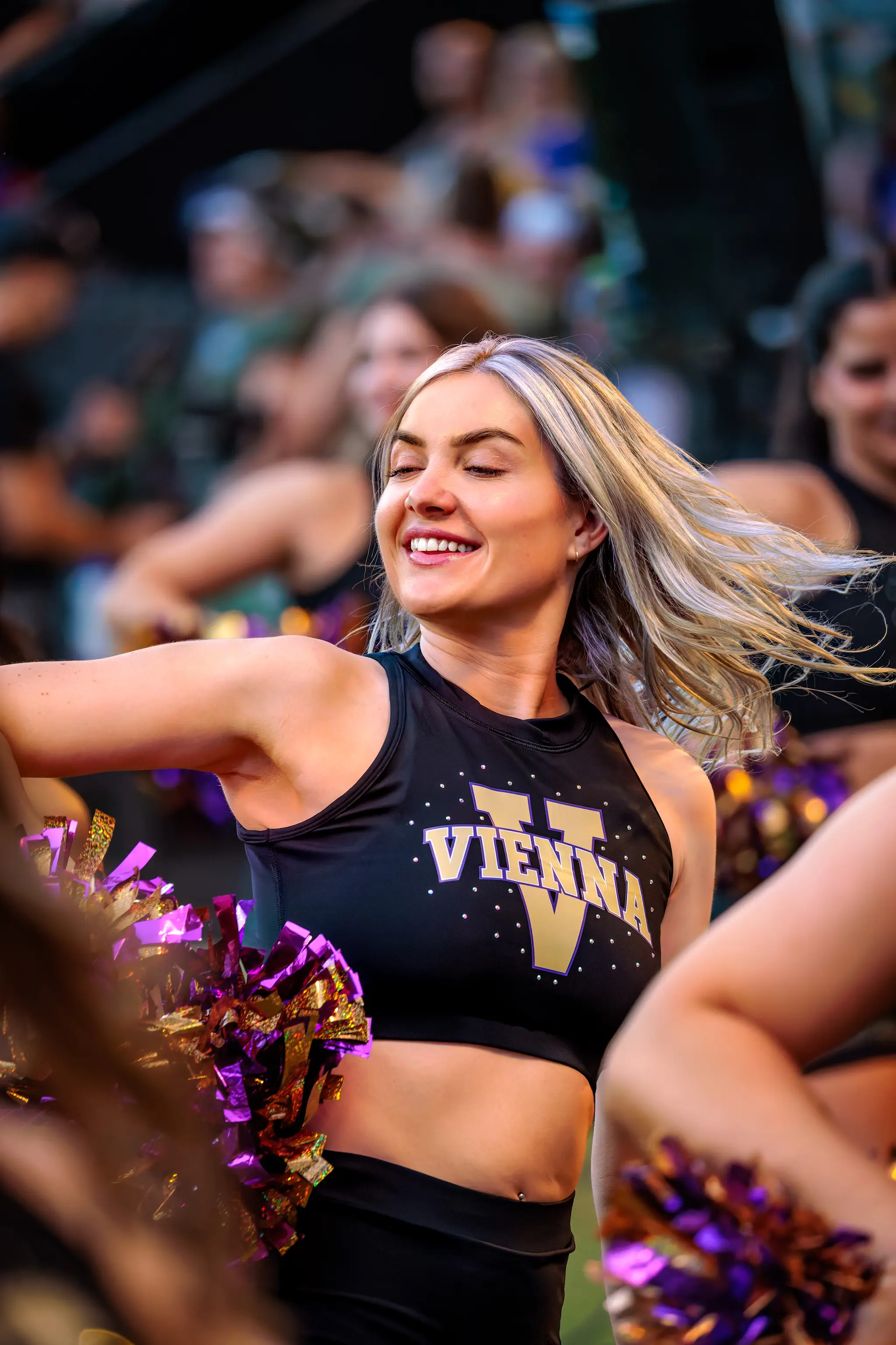 Porträt einer lächelnden Cheerleaderin des Spirit Squad während der Choreografie.