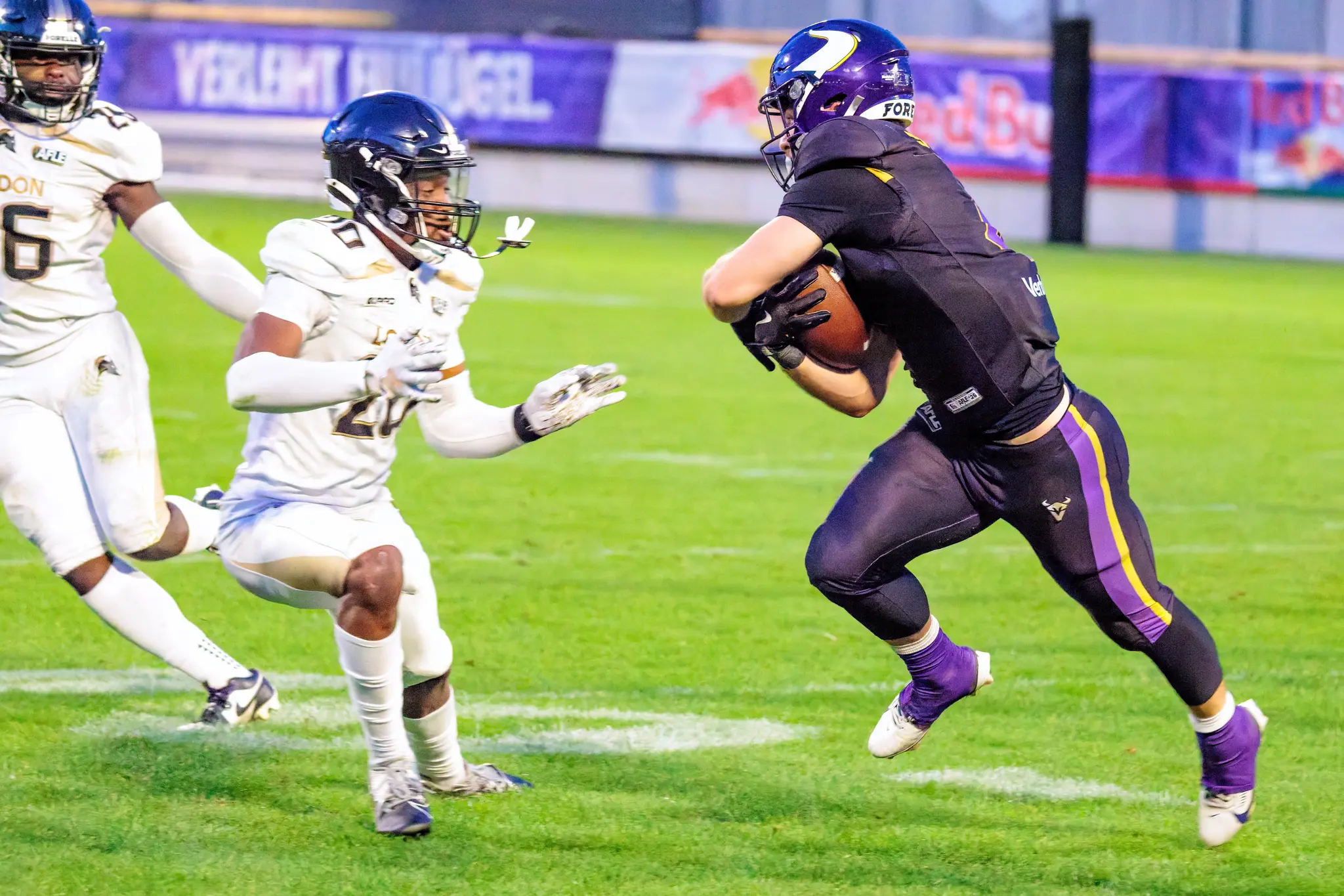 Ein Ballträger der Vienna Vikings läuft mit dem Ball auf und davon, verfolgt von den London-Verteidigern (20, 26) – Laufspiel im dritten Viertel gegen die Warriors.
