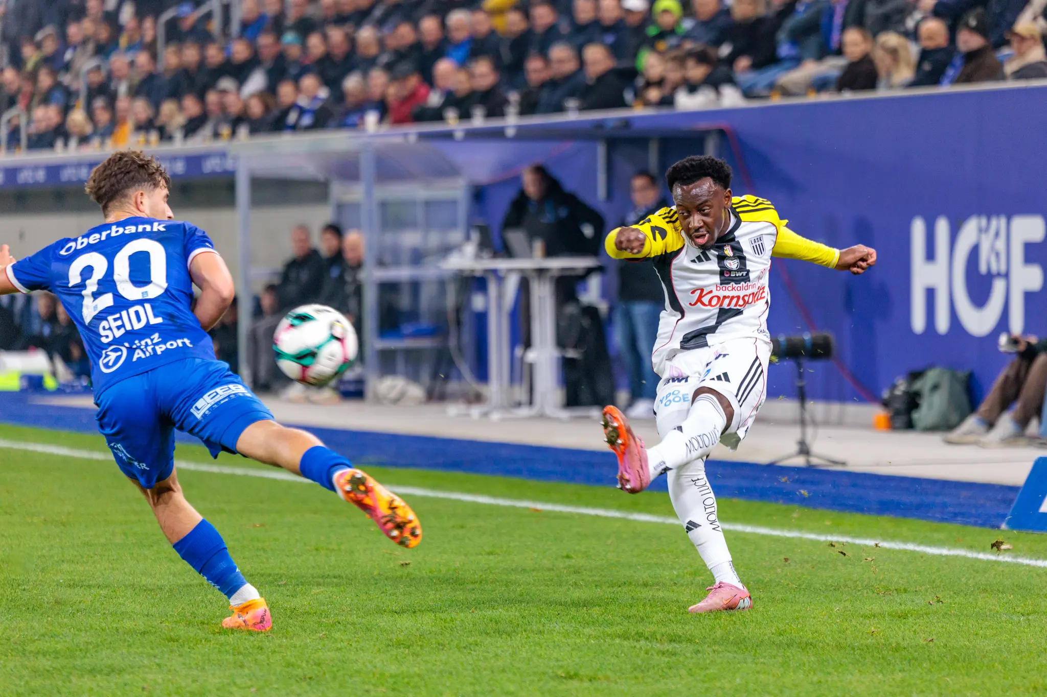 LASK-Angreifer Moses Usor zieht im Linzer Derby kraftvoll ab, während Simon Seidl von Blau-Weiß Linz versucht, den Torschuss zu blocken