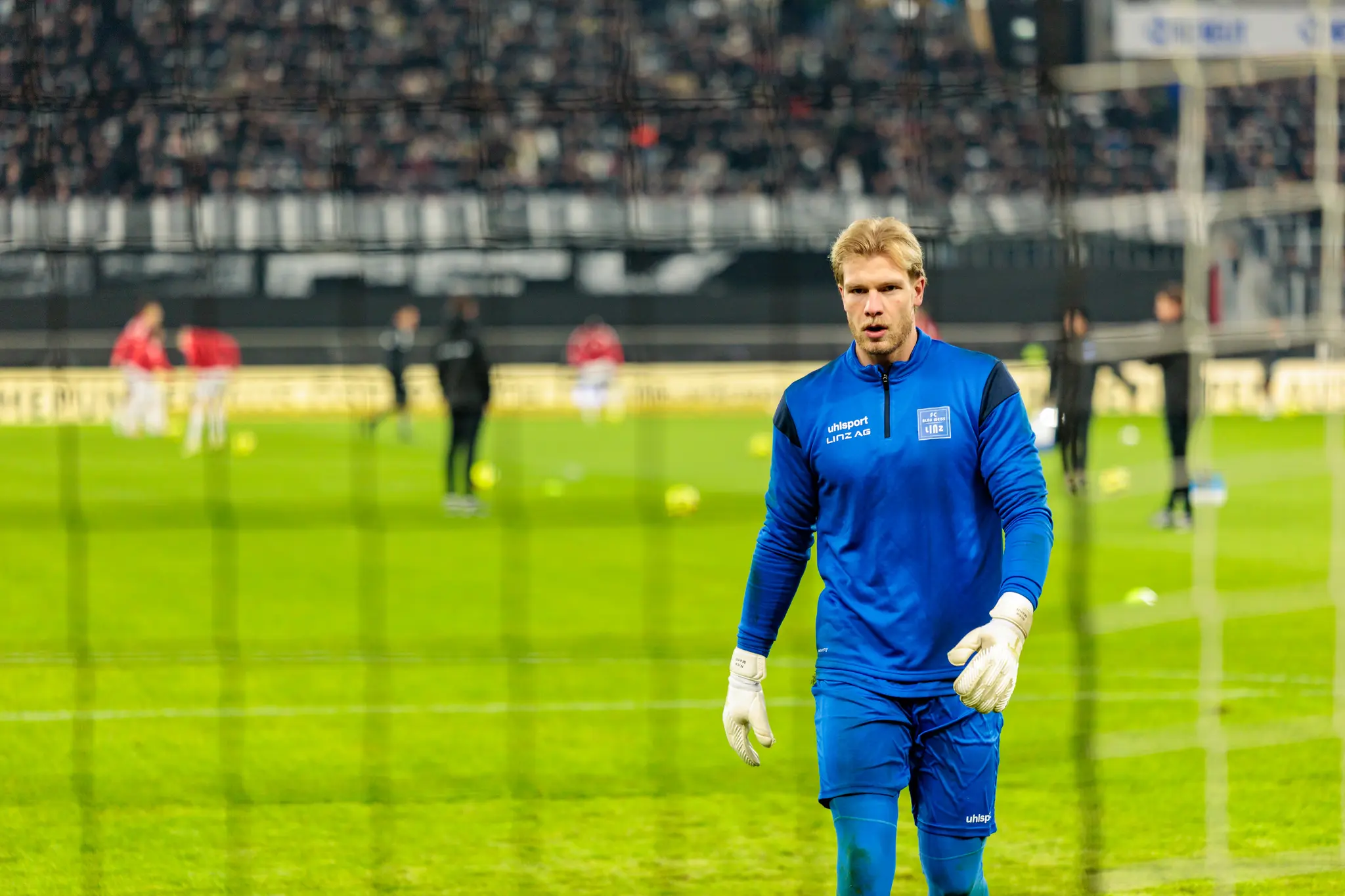 Blau-Weiß Linz Torhüter Nico Mantl blickt konzentriert mit weißen Torwarthandschuhen beim Linzer Derby im ÖFB-Cup gegen den LASK