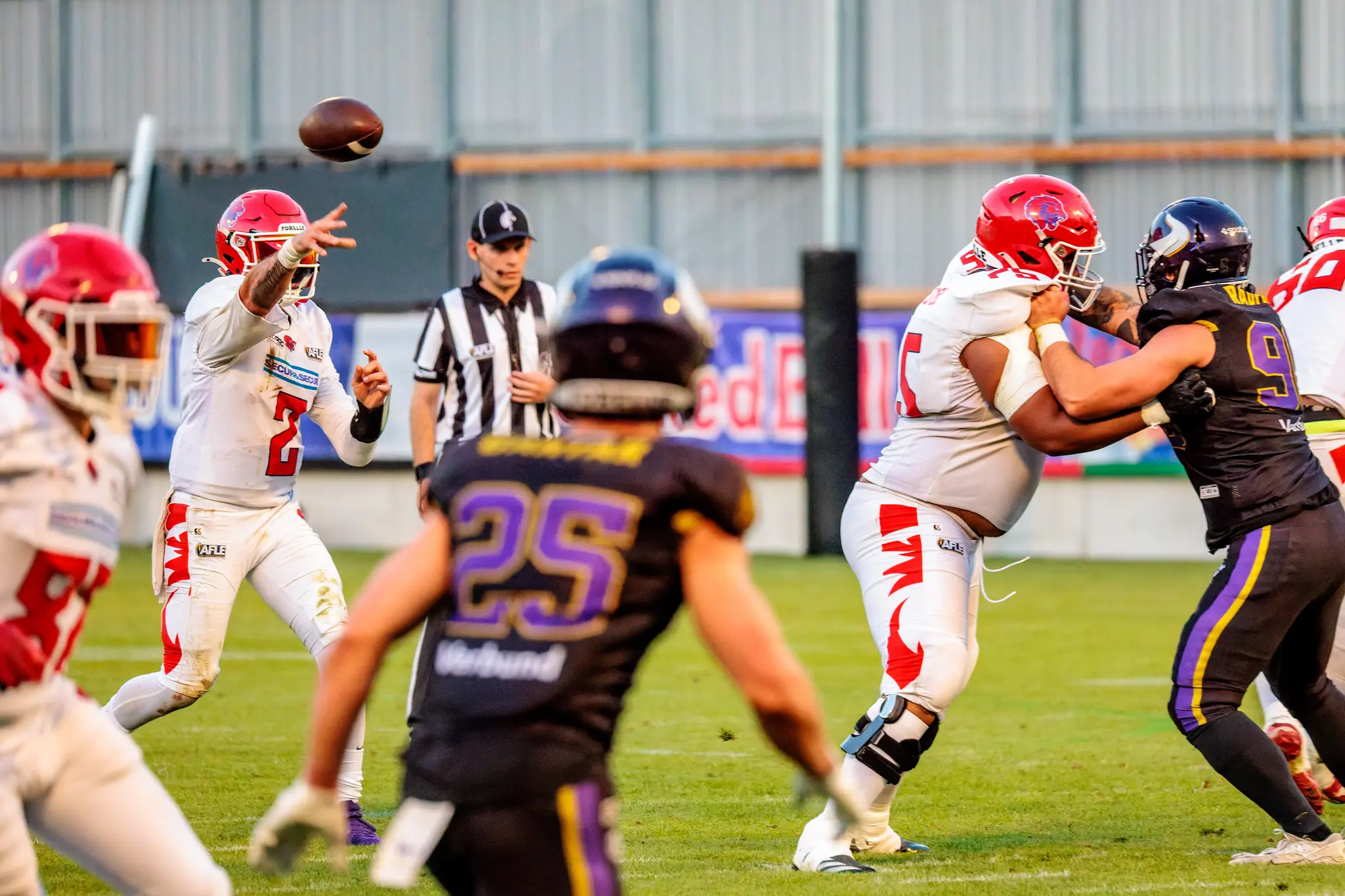 Passversuch der Gäste: Der Quarterback der Red Lions (Nr. 2) wirft unter Druck, während Manuel Radfux (90) gegen den schweren Block ankämpft und Linus Gantar (25) in der Tiefe lauert.
