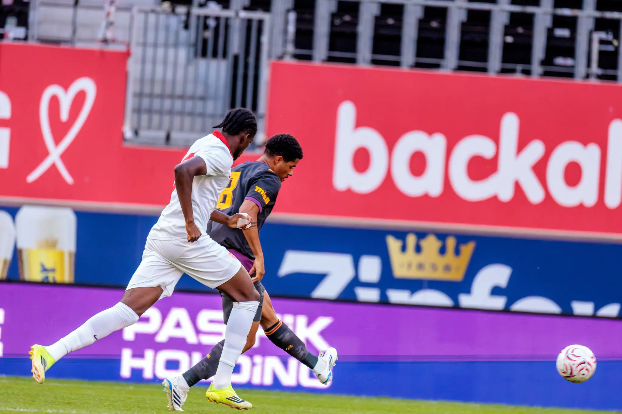 Galatasaray-Spieler mit Dreadlocks behauptet sich beim Pass gegen Monza-Spieler Nummer 8.