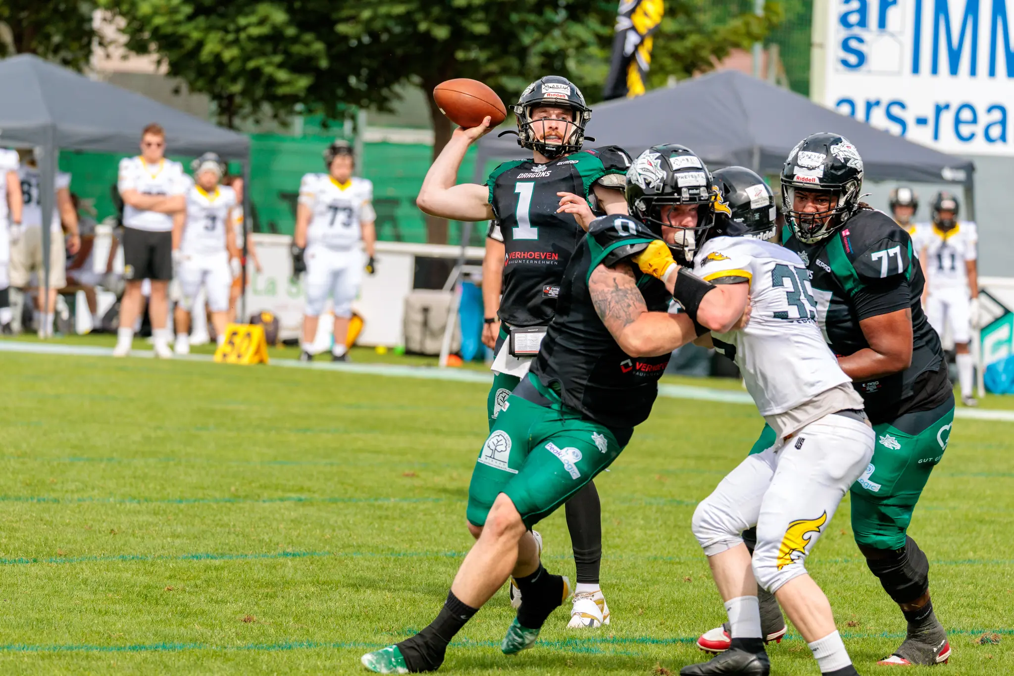 Ein Quarterback der Danube Dragons führt einen Pass aus, während die Vienna Knights versuchen, ihn zu tackeln