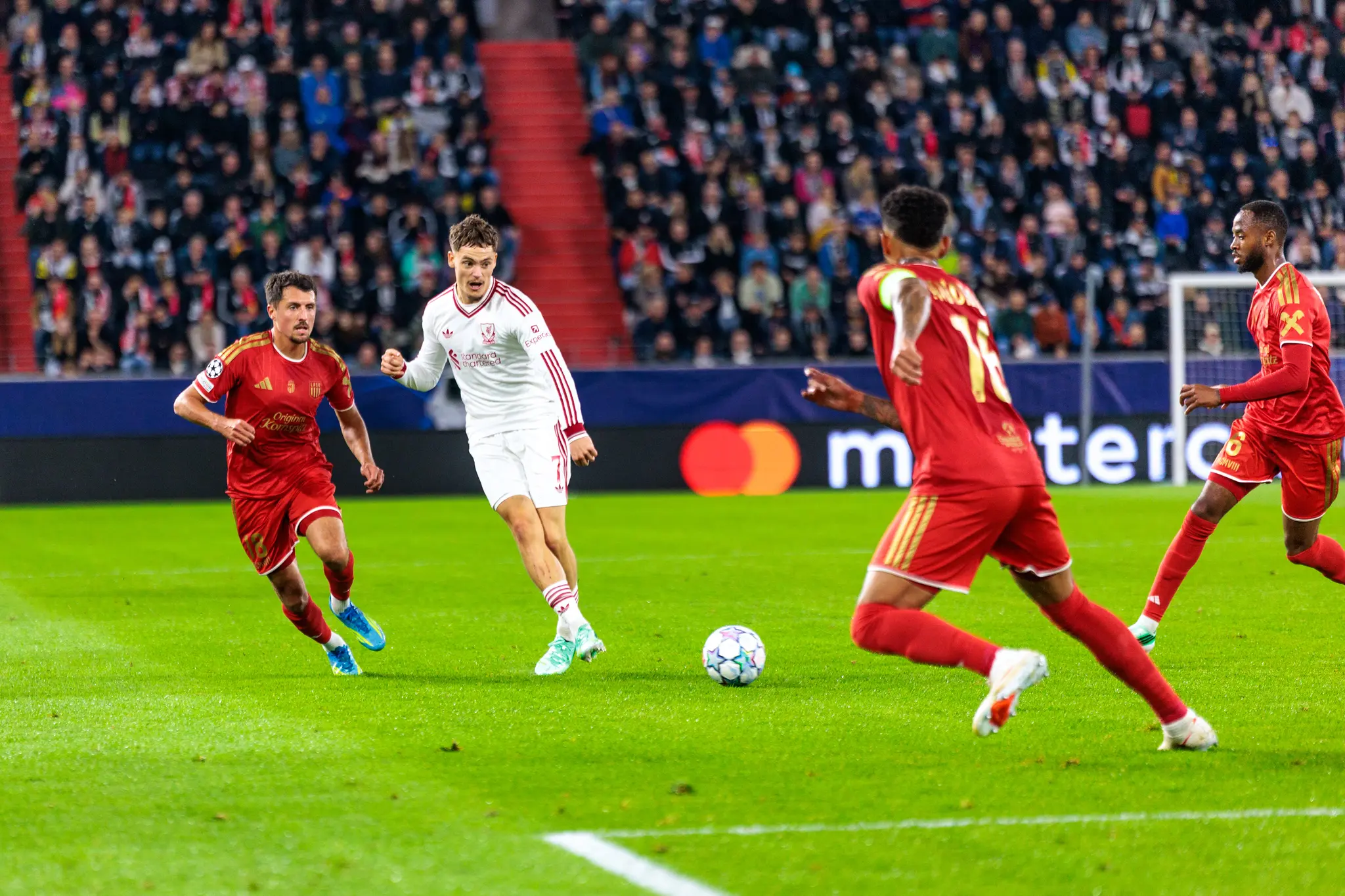 Florian Wirtz (7) treibt den Ball für Liverpool nach vorne, ein LASK-Spieler läuft neben ihm mit.