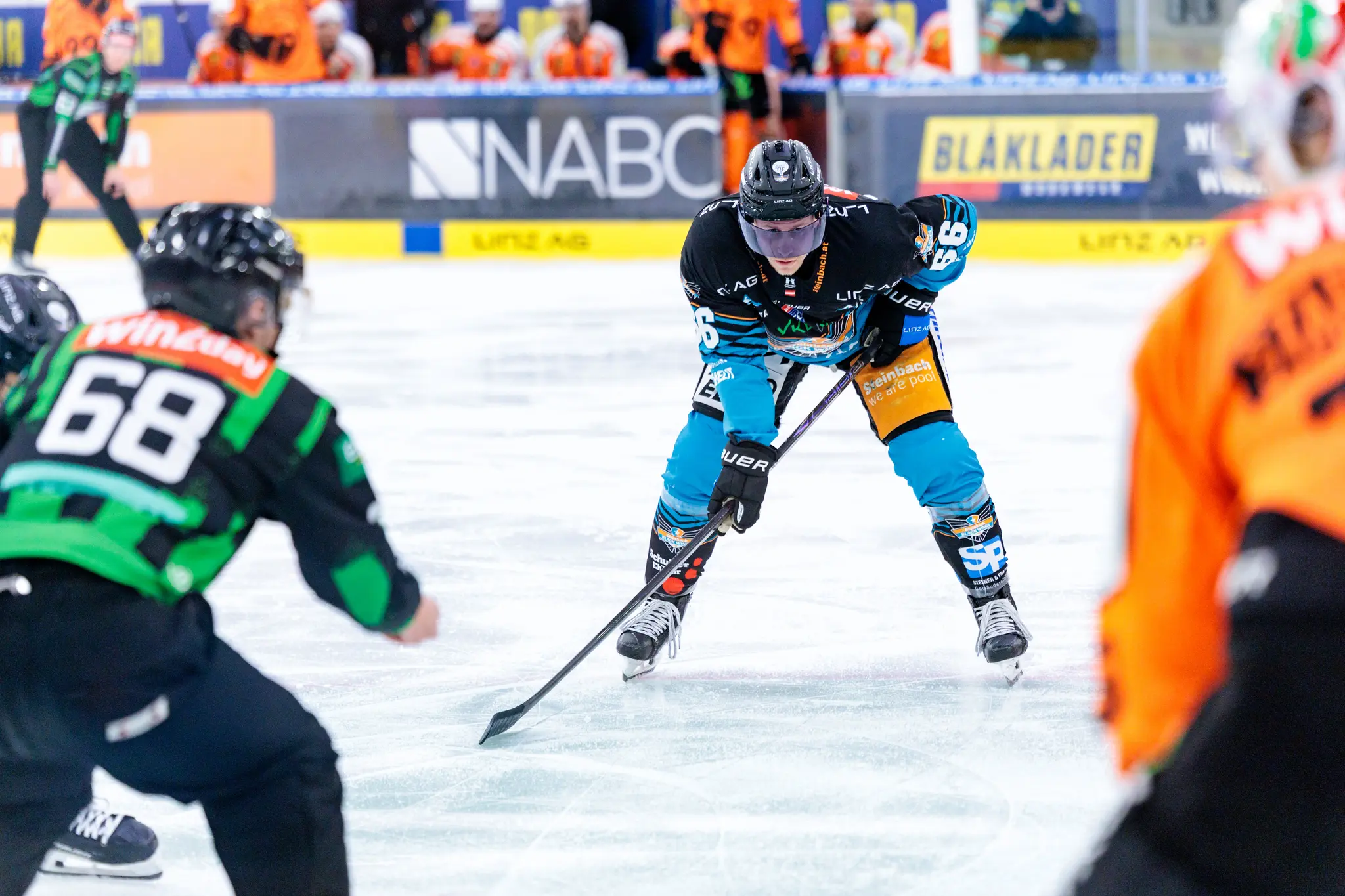 Zwei Eishockeyspieler, einer der Black Wings Linz und einer der Grazer 99ers, stehen auf dem Eis bereit für ein Bully