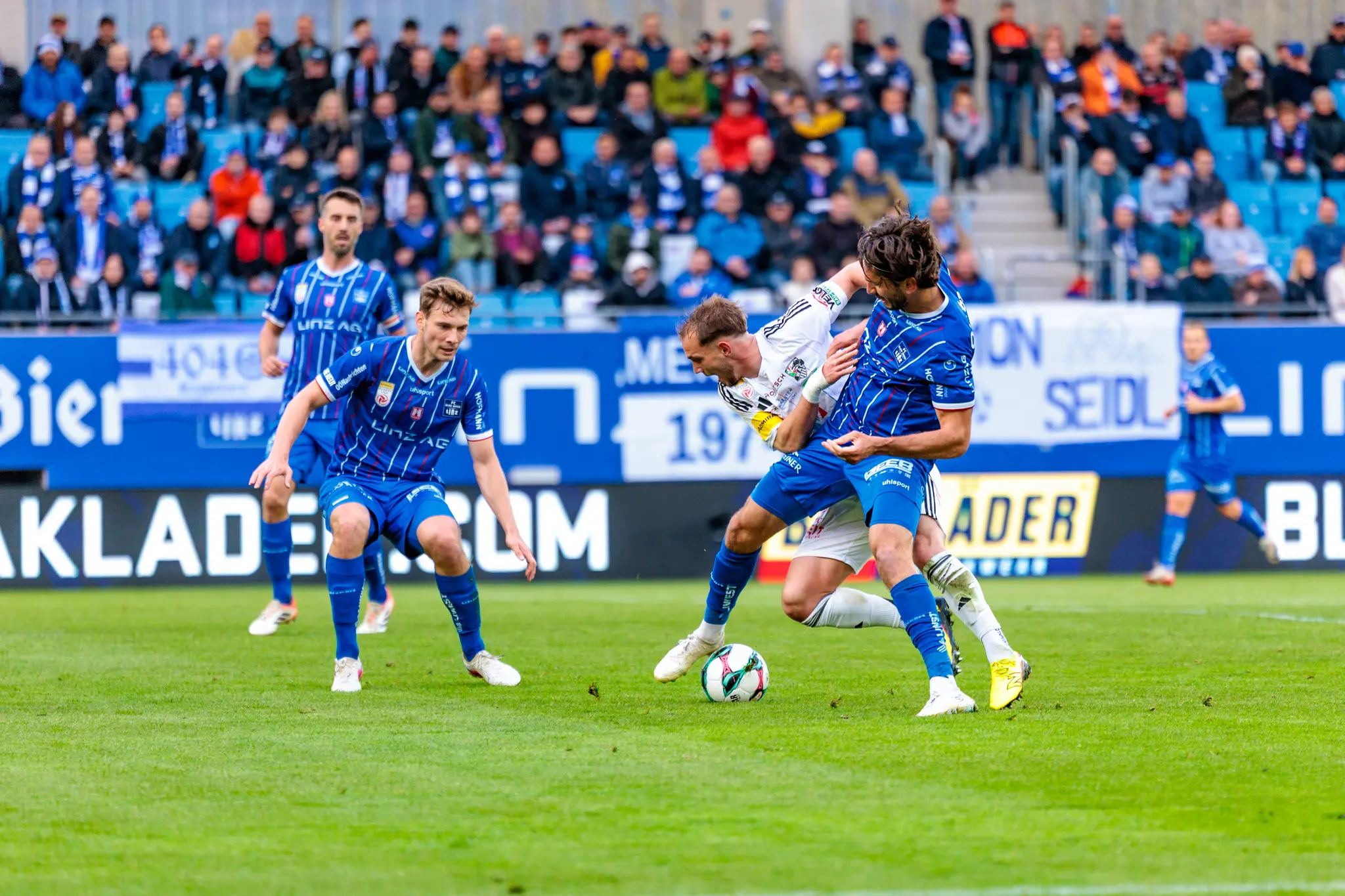 Ein Spieler des Wolfsberger AC wird im Zweikampf um den Ball durch einen Gegenspieler des Blau-Weiß Linz zu einem Foul an der Strafraumgrenze gebracht