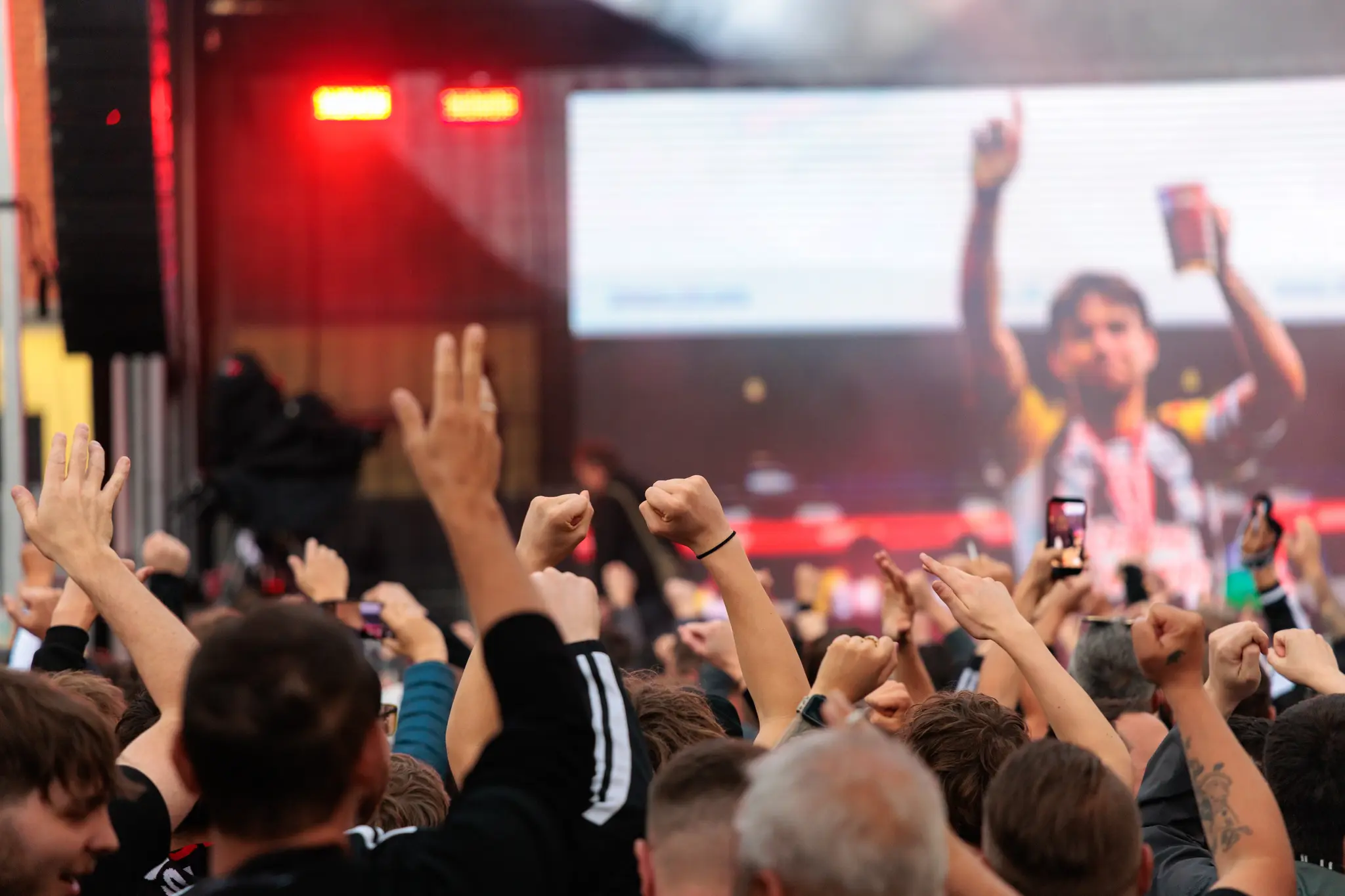 Begeisterte LASK-Fans blicken während der Meisterfeier auf eine große Leinwand mit einer Foto-Diashow und warten auf die Ankunft der Mannschaft
