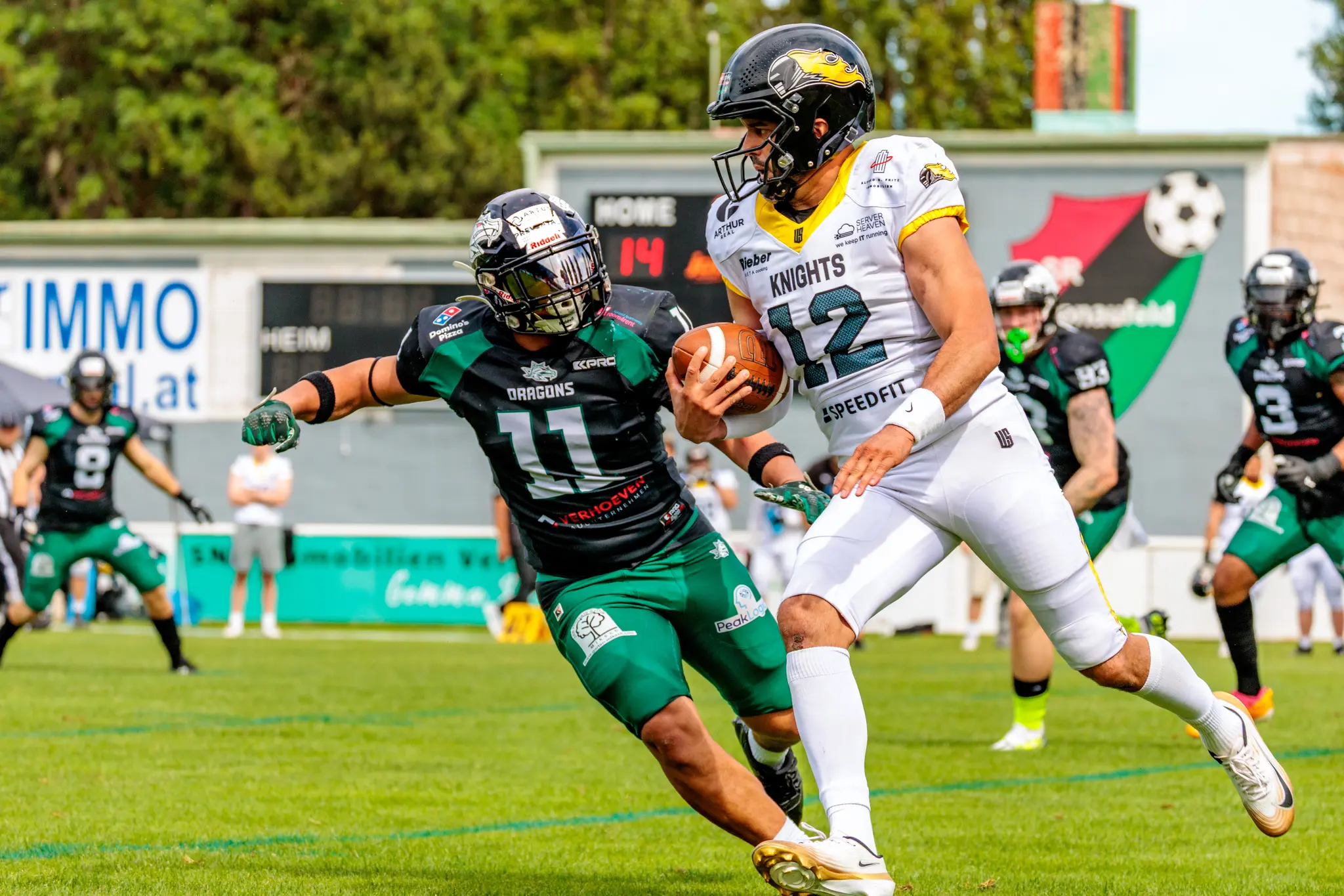 Ein Spieler der Vienna Knights mit dem Football in den Händen wird von einem Danube Dragons Verteidiger während eines AFL-Spiels markiert