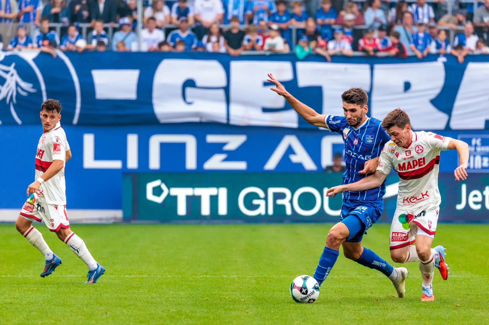 Der Stürmer von Blau-Weiß Linz, Shon Weissman, dribbelt mit dem Ball und wird im Zweikampf von Thorsten Schriebl vom GAK bedrängt