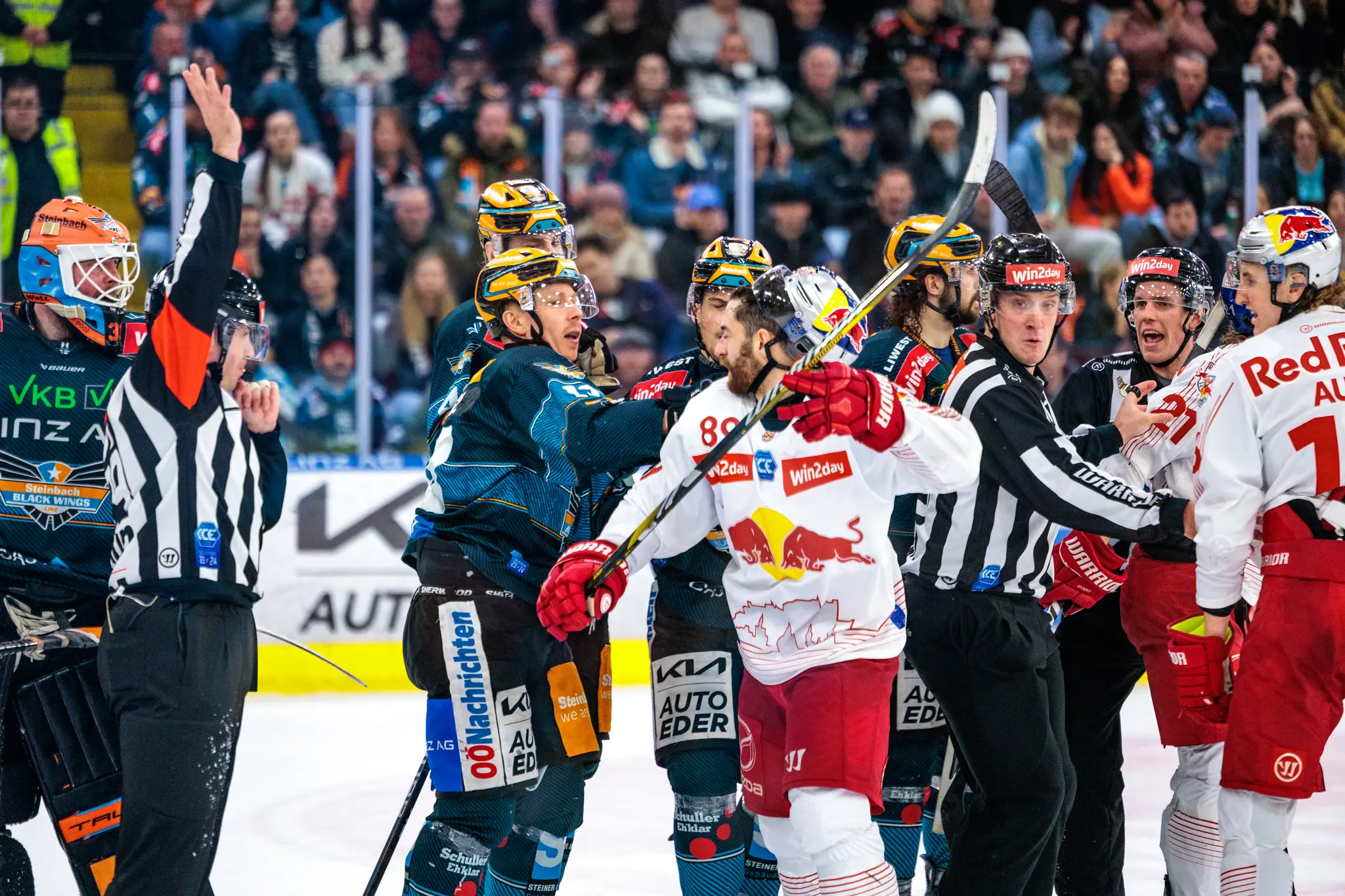 Eishockeyspieler der Black Wings Linz und Red Bull Salzburg geraten auf dem Eis aneinander, während Schiedsrichter versuchen, die Situation zu beruhigen