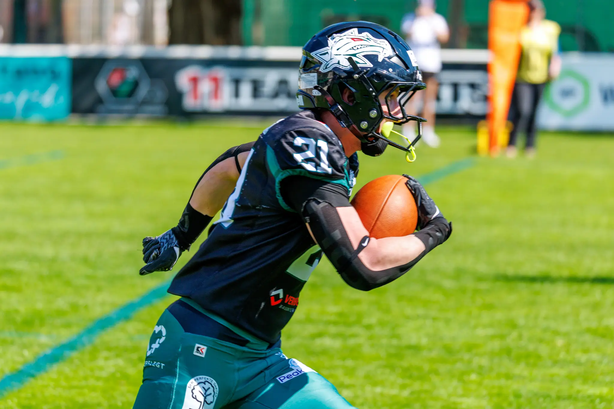 Ein American Football Spieler der Danube Dragons läuft während des AFL-Heimspiels gegen die Prague Black Panthers fokussiert mit dem Ball im Arm