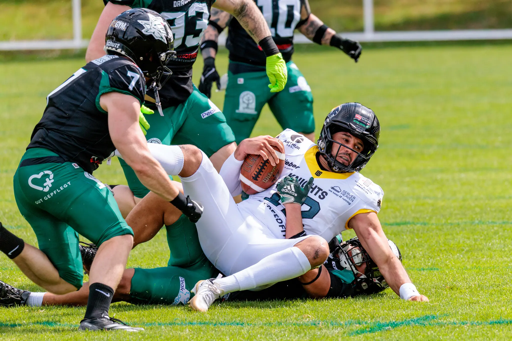 Ein Spieler der Vienna Knights wird von der Defense der Danube Dragons am Boden getackelt