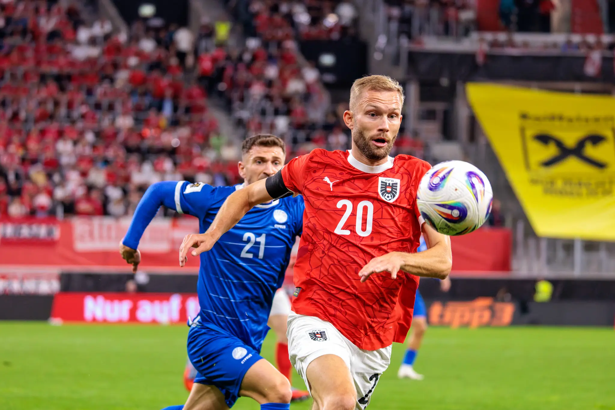Konrad Laimer, Österreichs Nummer 20, behauptet den Ball im Laufduell gegen Marinos Tzionis, Zyperns Nummer 21, während des Fußballspiels