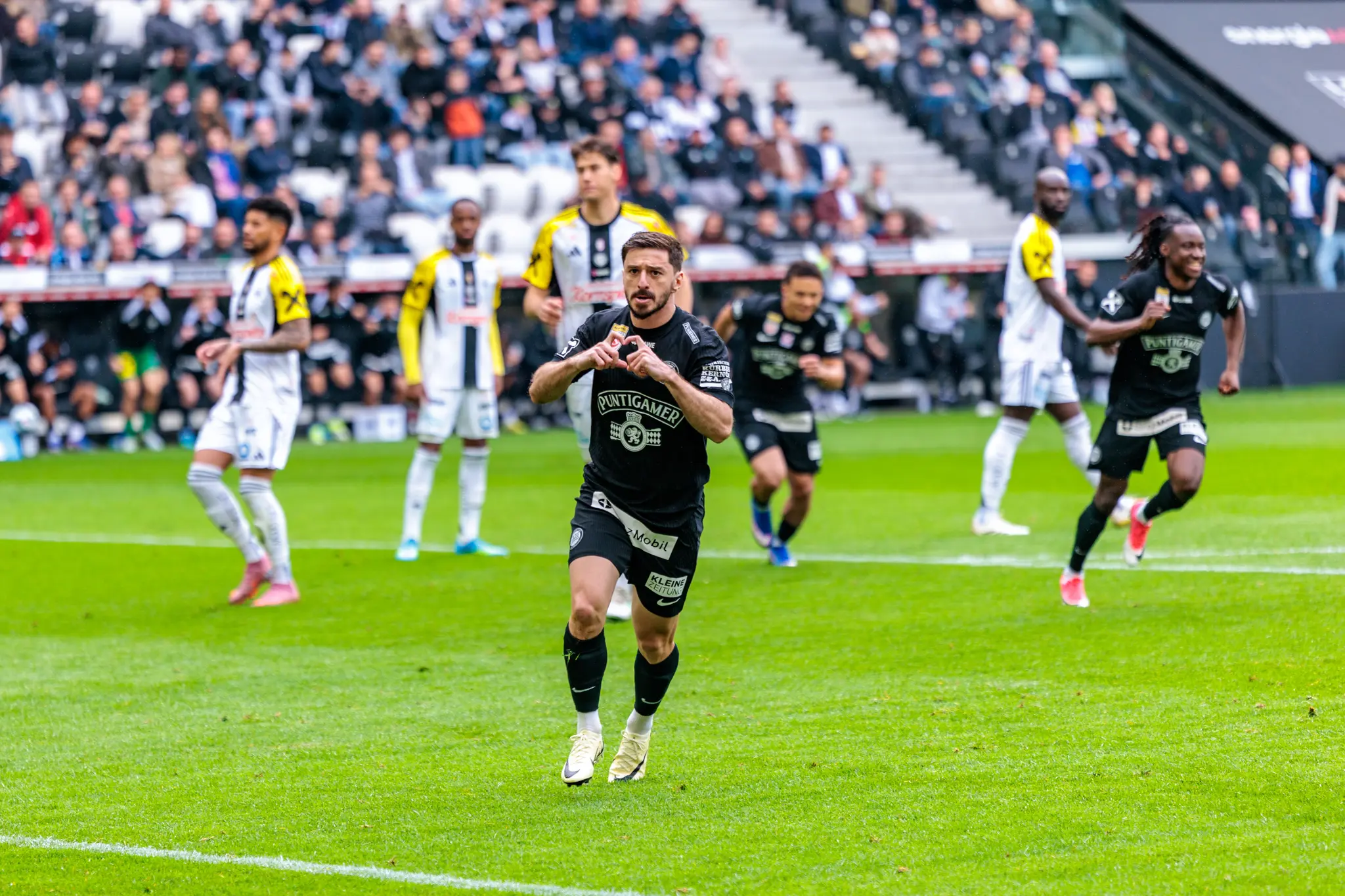Ein Sturm Graz Spieler feiert nach einem Tor mit einer Herzgeste vor den Zuschauern