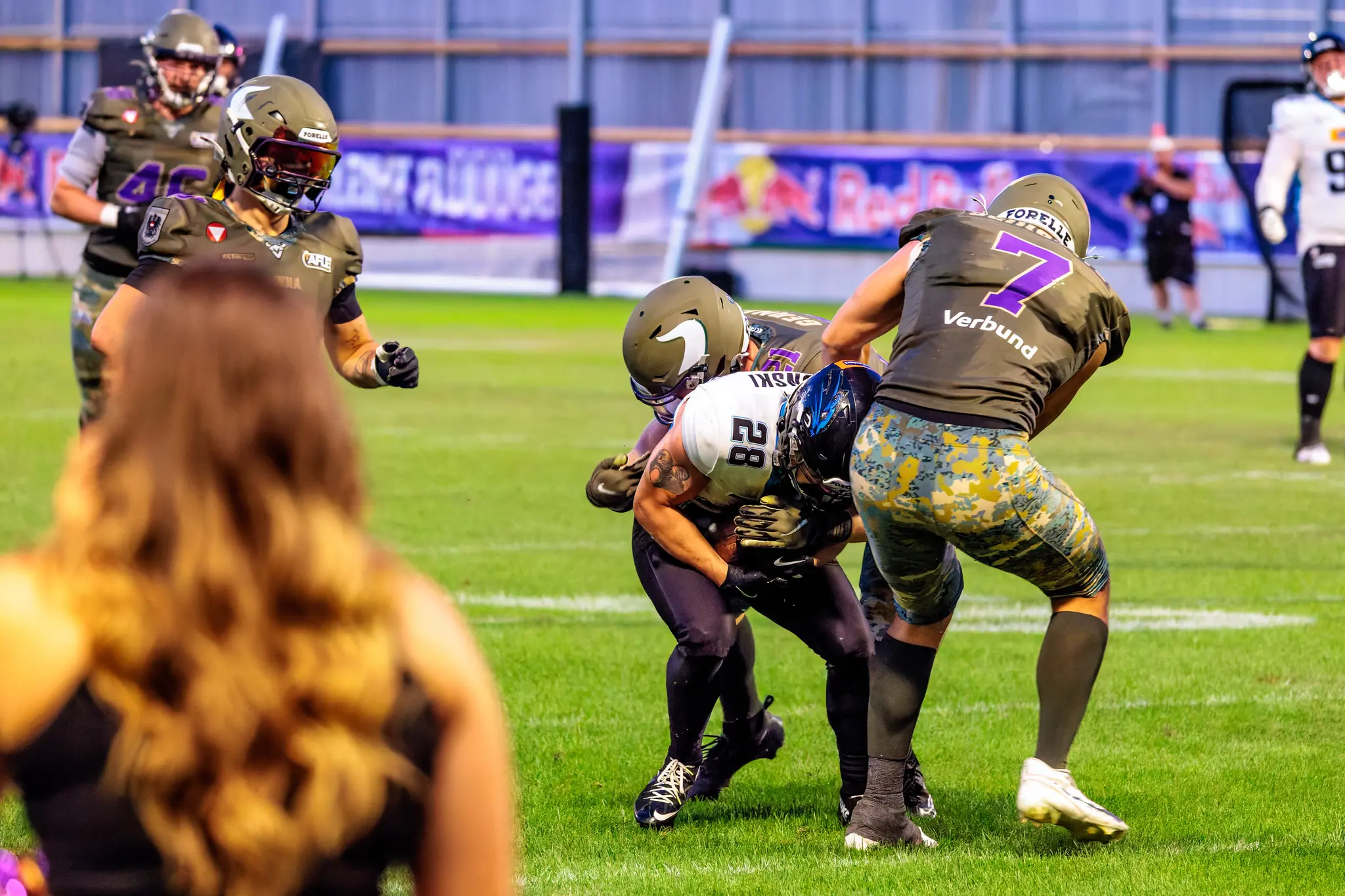 Panthers-Spieler Nummer 28 läuft mit dem Ball, Vikings-Spieler Bernhard Seikovits (Nummer 7) greift von rechts an.