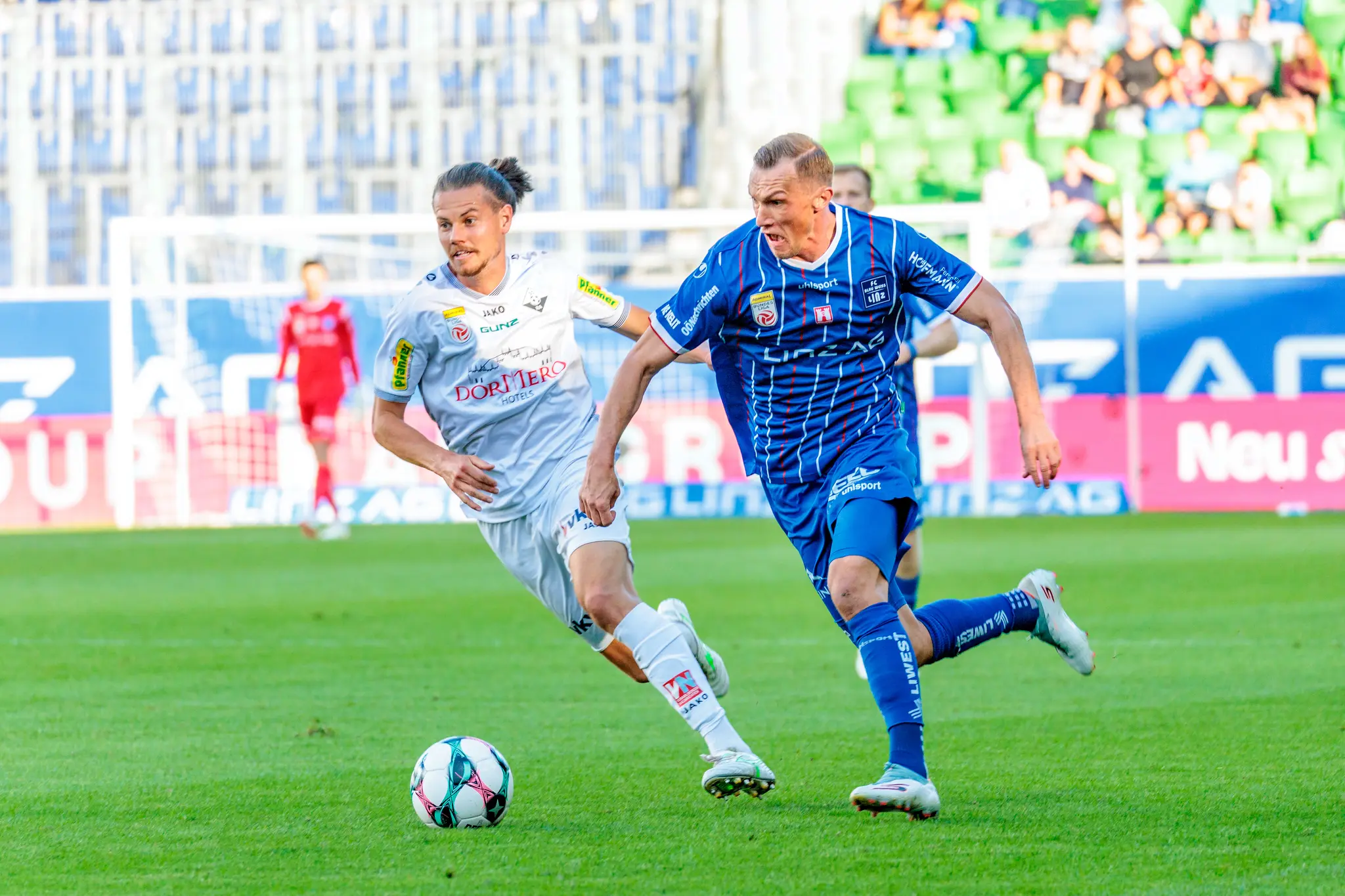Der Blau-Weiß Linz Spieler Manuel Maranda bestreitet ein intensives Laufduell gegen einen ballführenden Gegenspieler vom SCR Altach