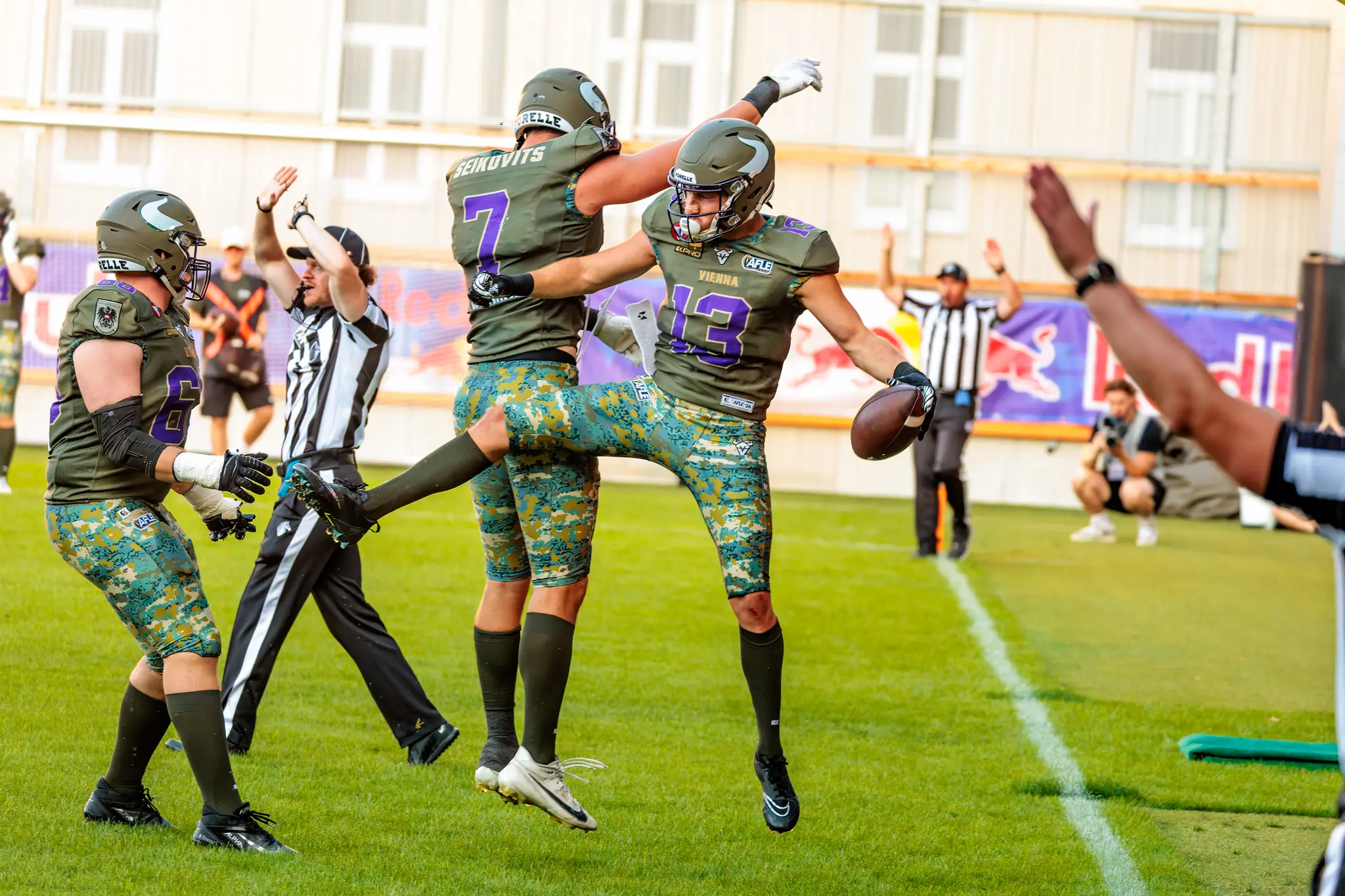 Vikings-Spieler Philipp Haun (Nummer 13) feiert in der Endzone, Bernhard Seikovits (Nummer 7) springt daneben hoch, der Schiedsrichter zeigt den Touchdown an.