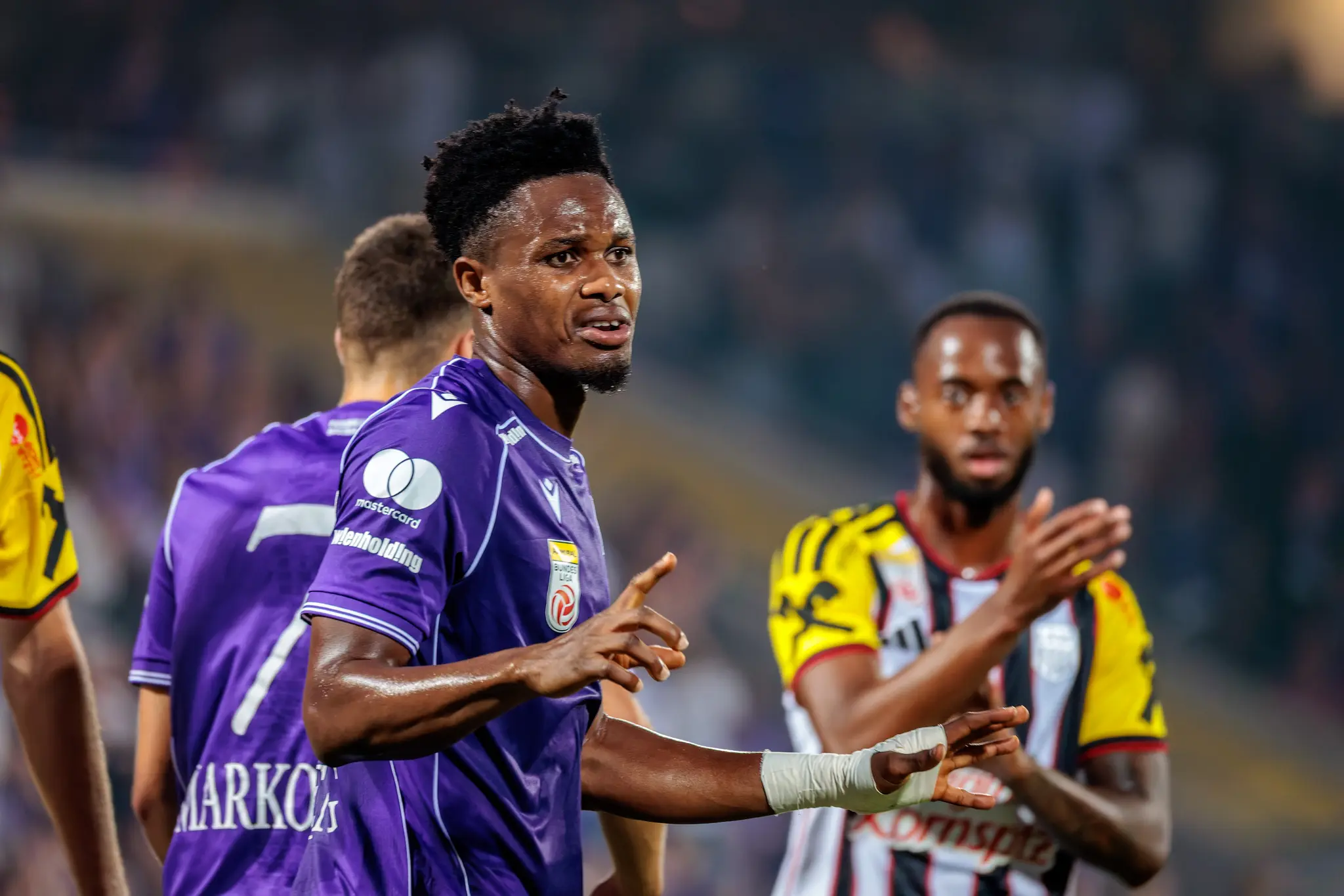 Austria-Spieler streitet das Handspiel ab, LASK-Spieler im Hintergrund zeigen mit dem Finger auf die Hand