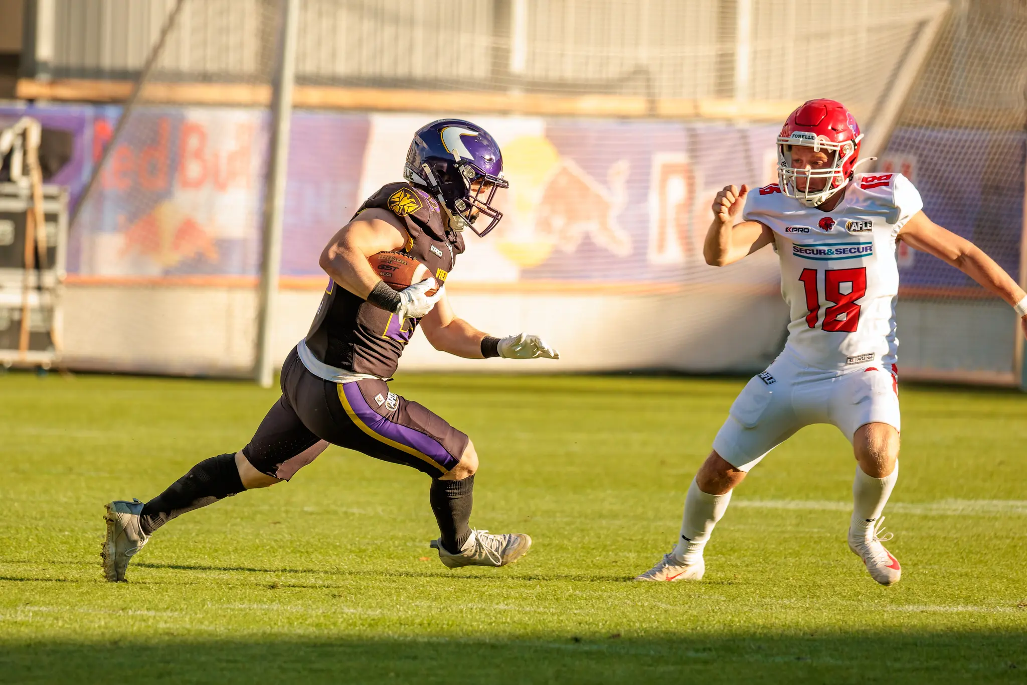 Im Abendlicht zieht ein Vikings-Ballträger am Red-Lions-Verteidiger (18) vorbei und behält die Kontrolle über Raum und Tempo – konzentrierte Offensive der Wiener.