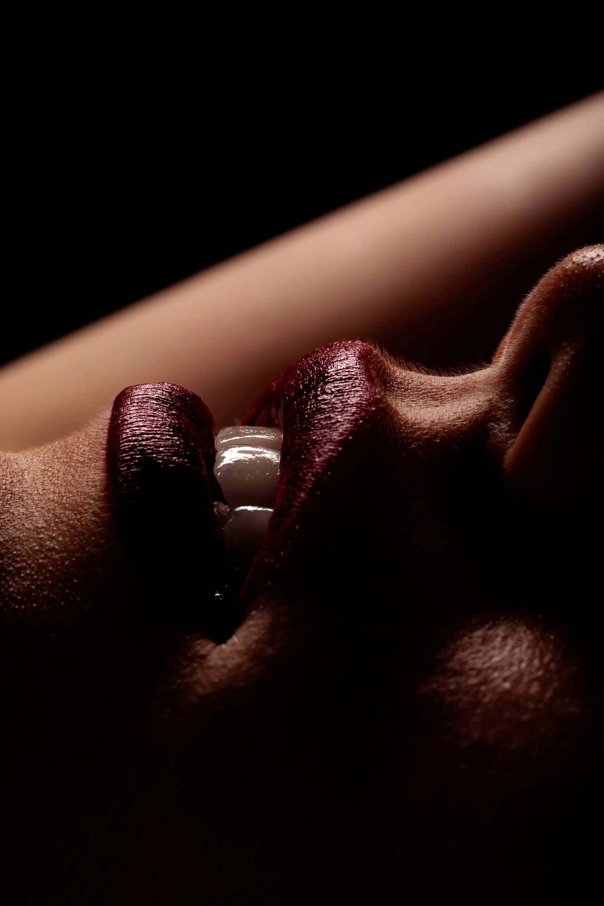 Ein stilvolles Nahaufnahme-Porträtdetail mit roten Lippen und strahlenden Zähnen in einem Spiel von Licht und Schatten 