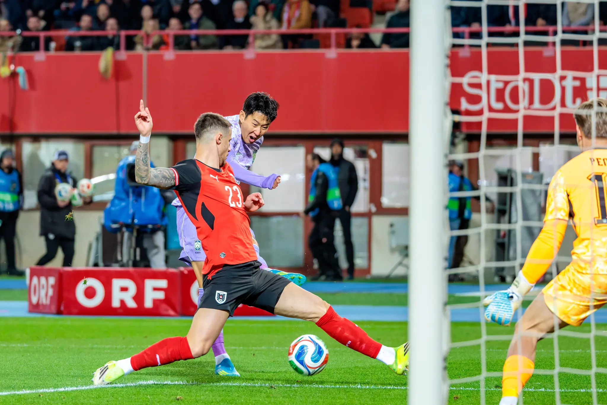Österreichs Nationalspieler Marco Friedl klärt den Ball mit einer präzisen Abgrätsche vor Heung-min Son im Strafraum während des Länderspiels gegen Südkorea
