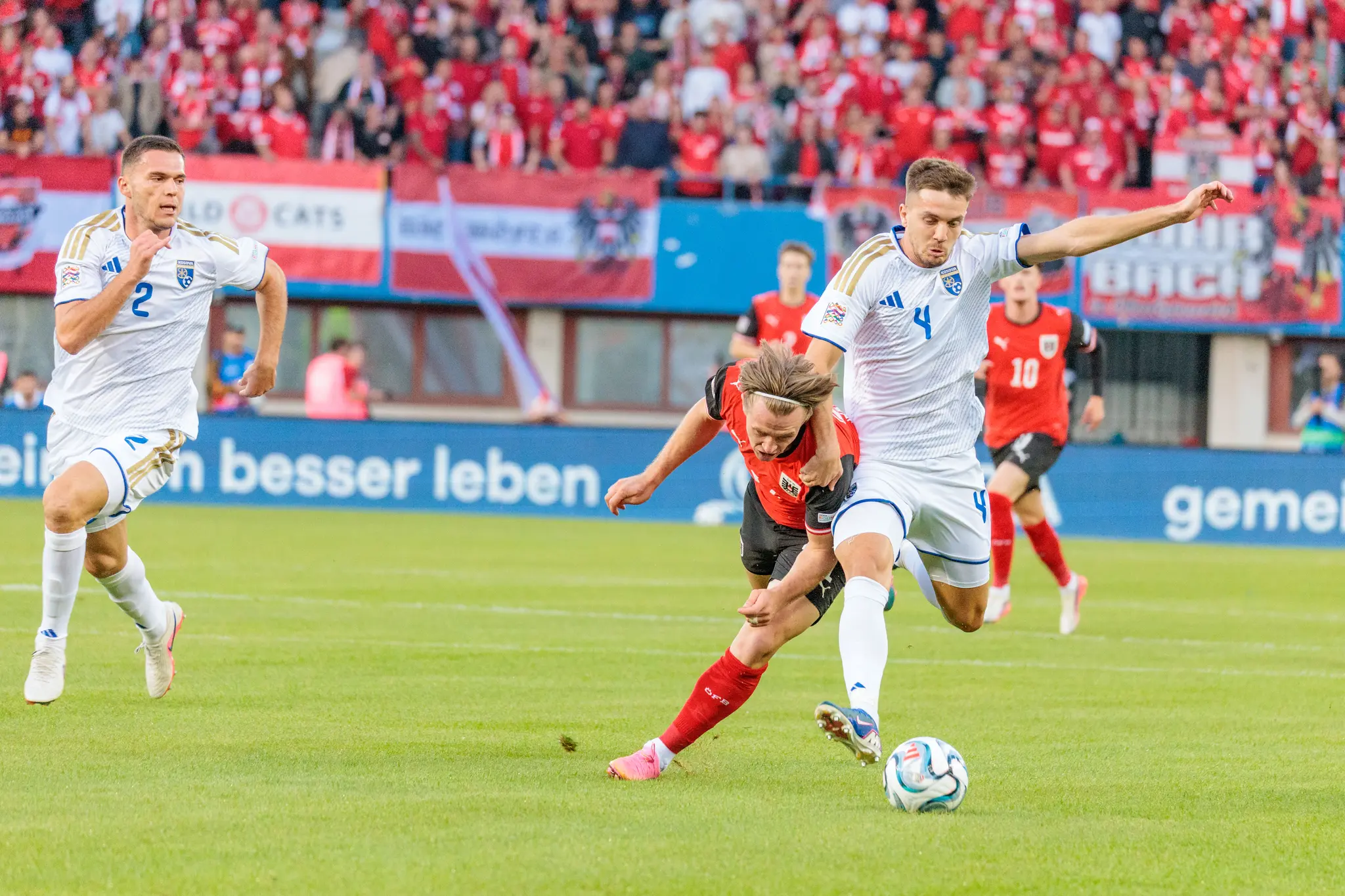 Ismajl Krasniqi (4) vom Kosovo behauptet den Ball gegen Patrick Wimmer (21), im Hintergrund läuft Paul Wanner (10) mit.