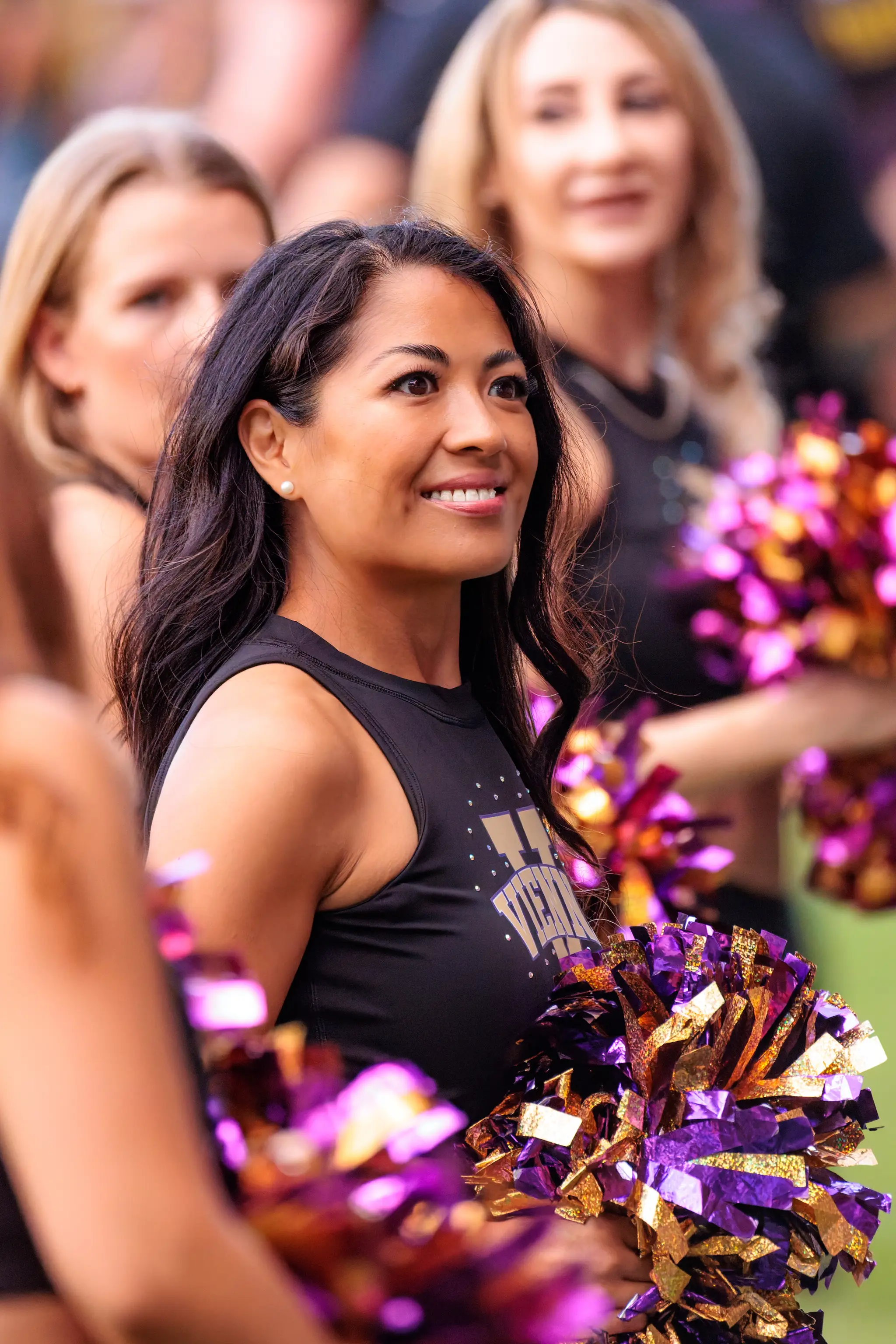 Breites Grinsen, Violett und Gold: Eine Tänzerin des Vienna Vikings Spirit Squad genießt den Abend am Sideline.