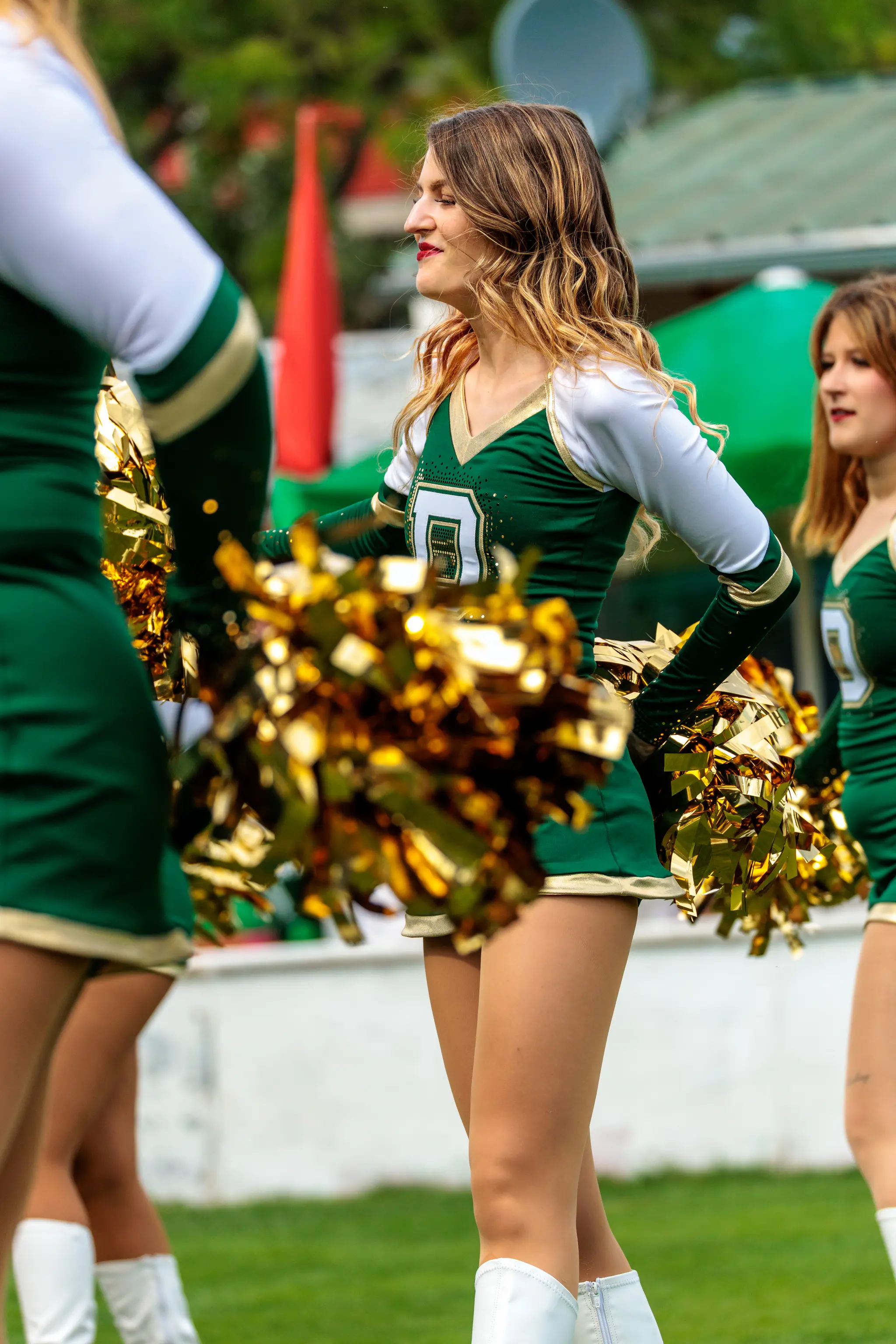 Cheerleader der Danube Dragons in grün-weißer Uniform mit goldenen Pompons beim AFL-Spiel gegen die Vienna Knights