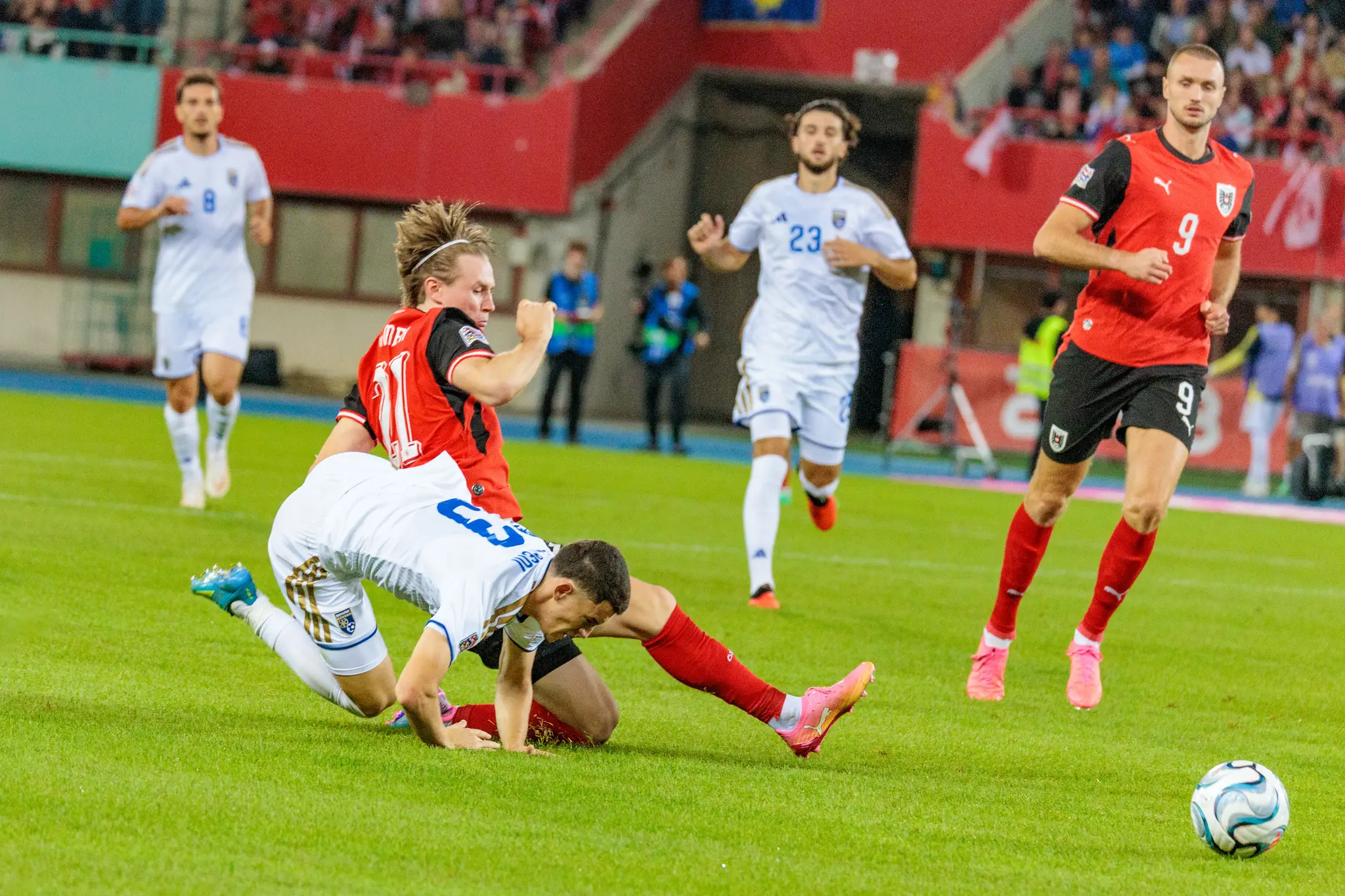 Im Zweikampf stürzt ein österreichischer Spieler über den am Boden liegenden Kosovaren Valmir Matoshi (8).