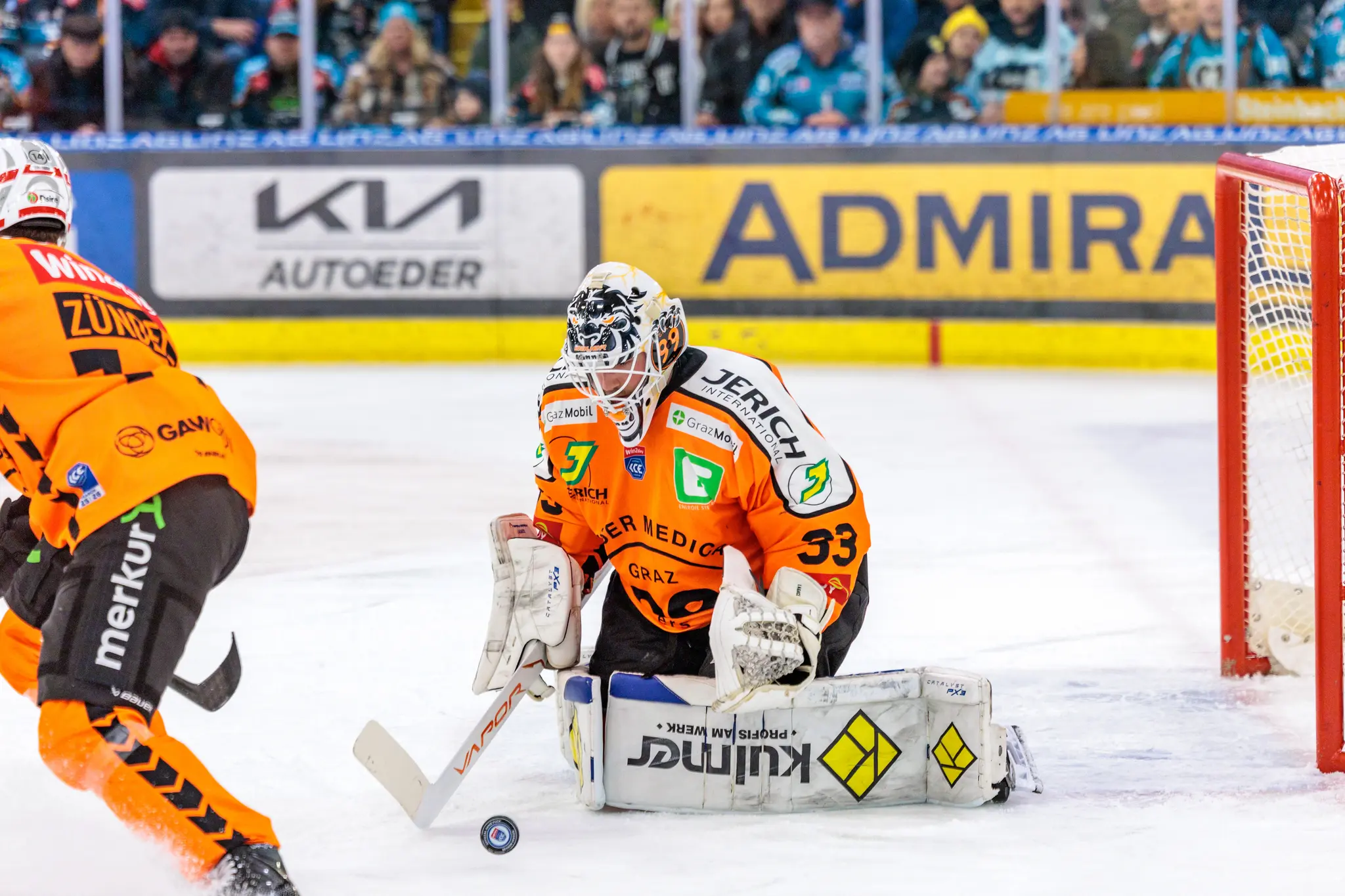 Der Torhüter der Graz99ers, Maxime Legace, kniet in voller Montur vor seinem Tor und beobachtet den Puck, der knapp vor ihm auf dem Eis liegt