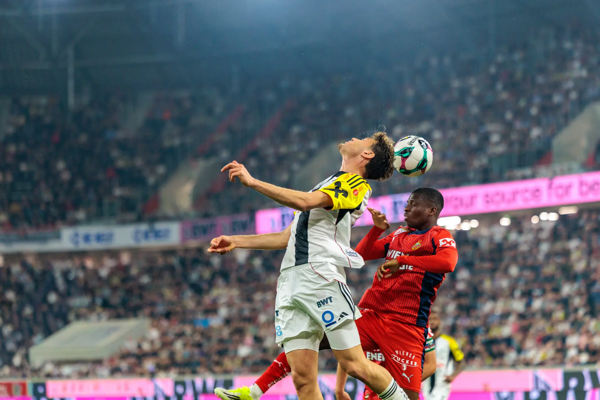 Ein Spieler des LASK und ein Spieler des SK Rapid kämpfen während eines Kopfballduells um den Ball